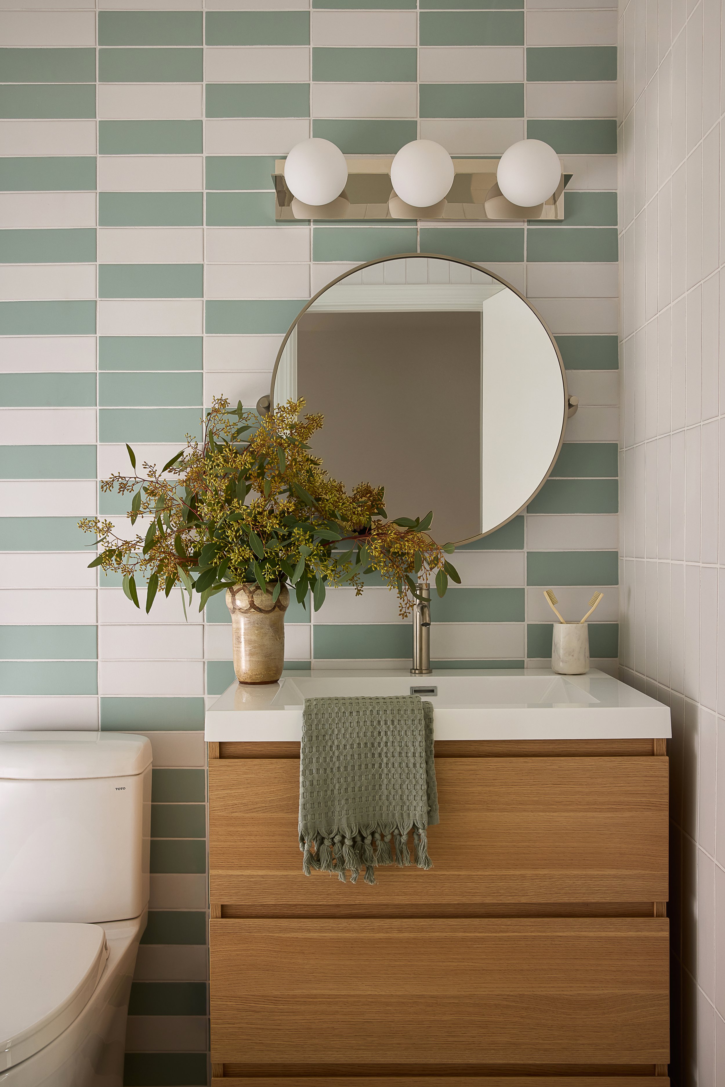 Residential bathroom vanity with white and green tile