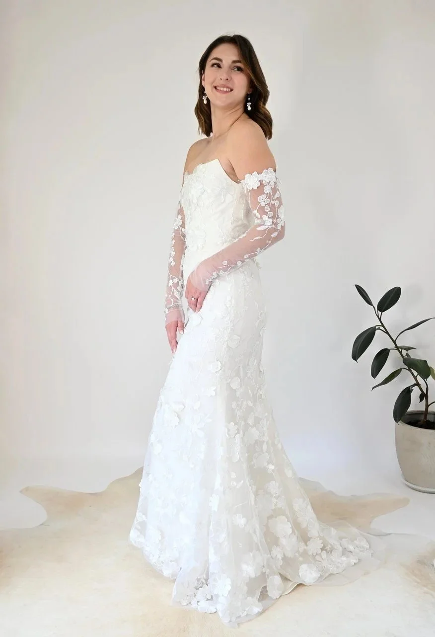 Bride in a strapless wedding dress with lace gloves and lace overlay. It's part of the Candilejas collection.