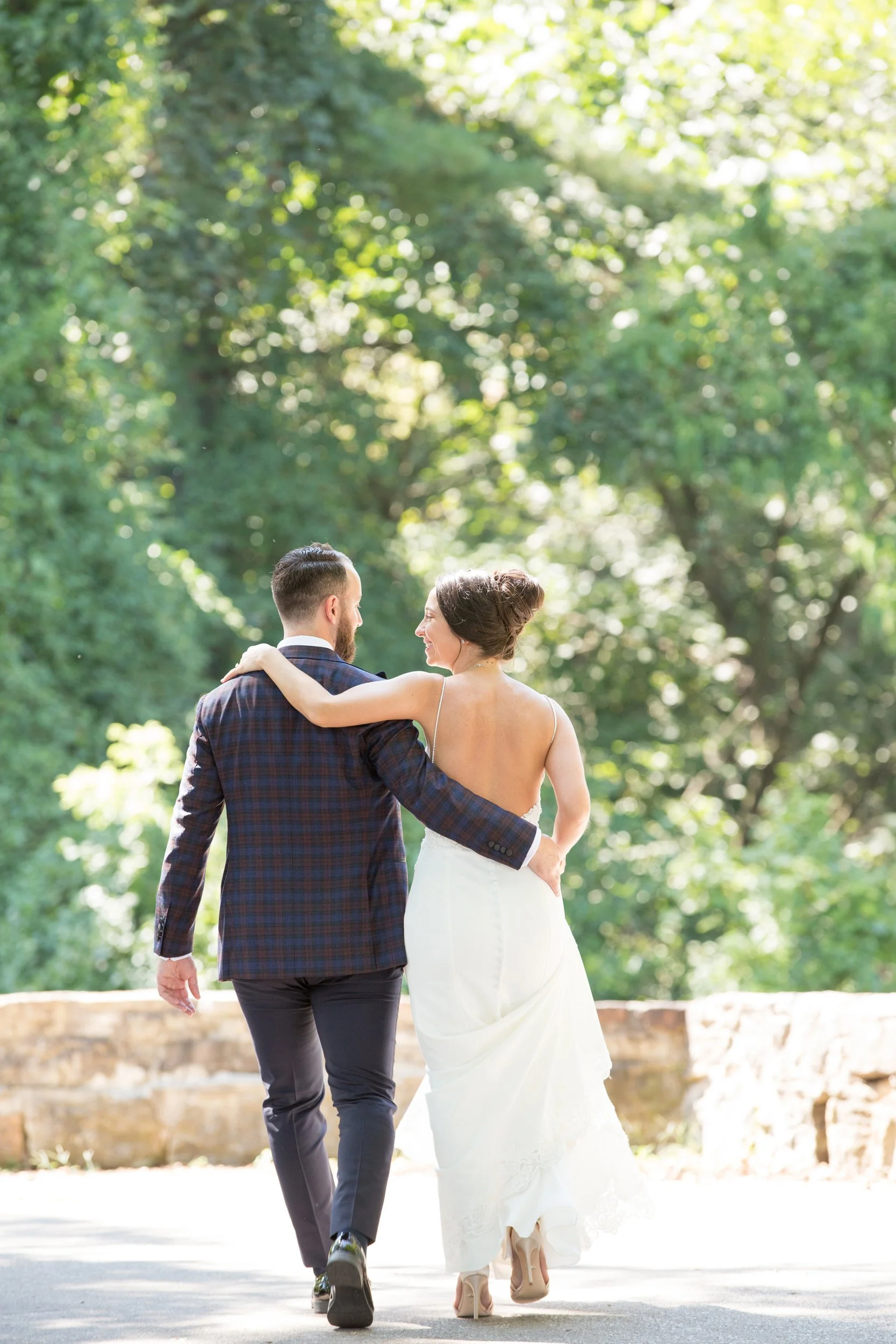 Bride and groom holding hands walking away in Hermann Hill, MO wine country.