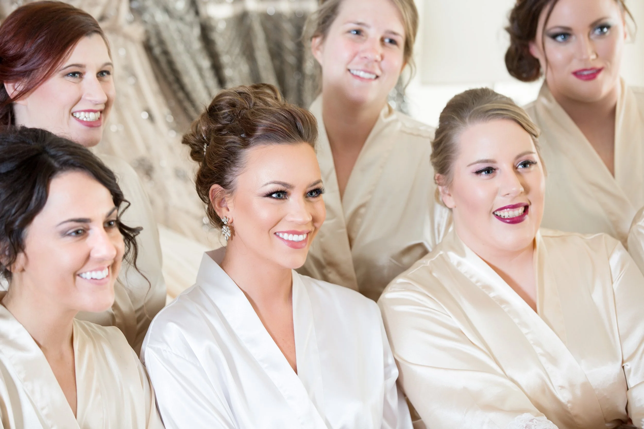 Joyful bride and bridesmaids smiling for the photo.