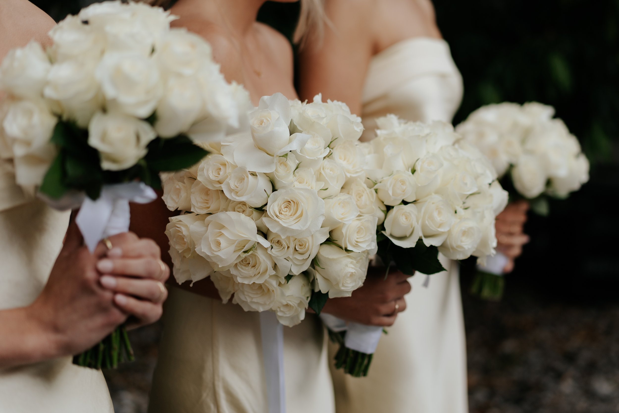 Bridesmaids holding yellow rose bouquets at a wedding ceremony held at Leonda by the Yarra.