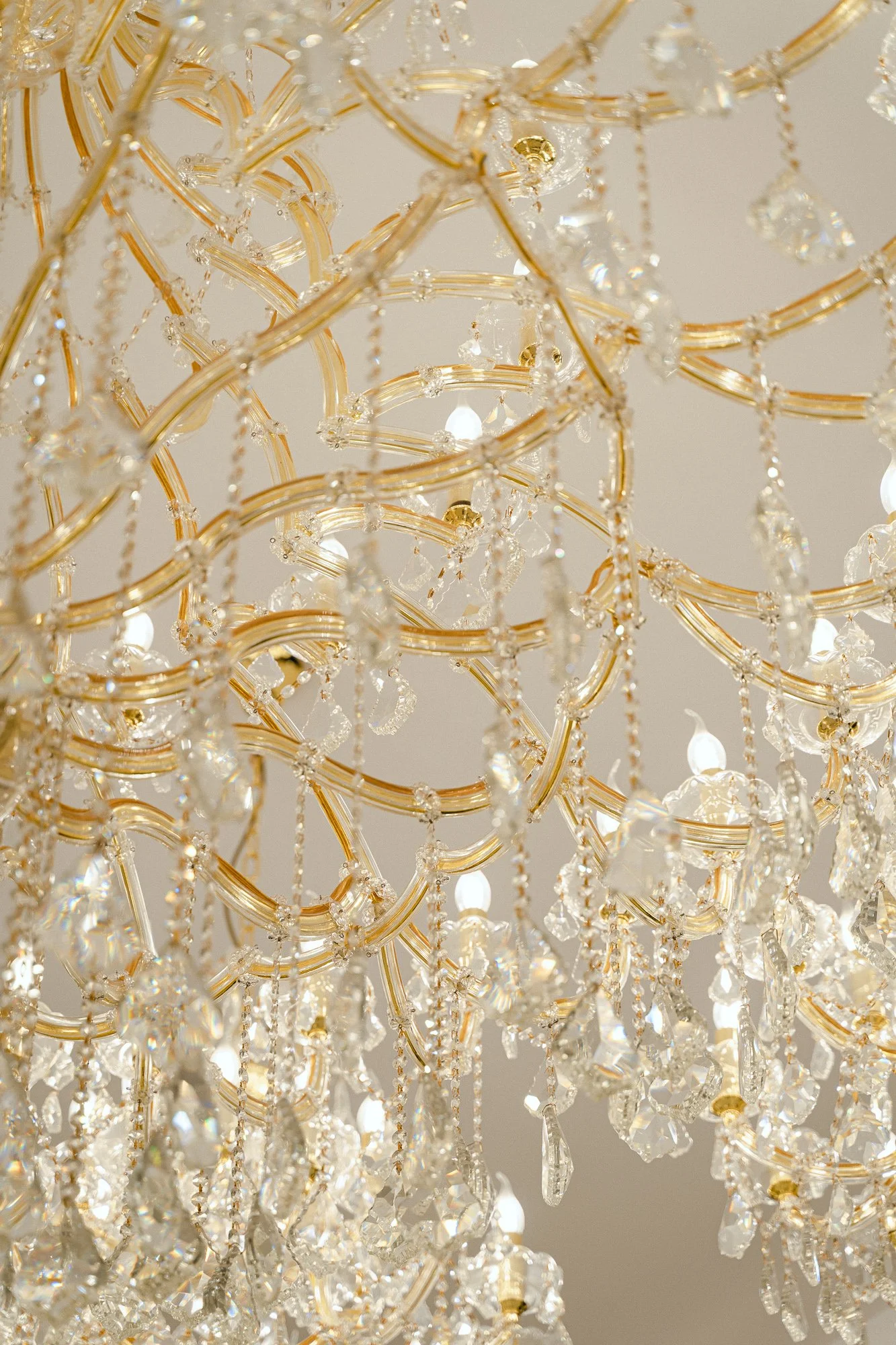 Close-up of a gold and crystal chandelier with hanging crystal prisms.