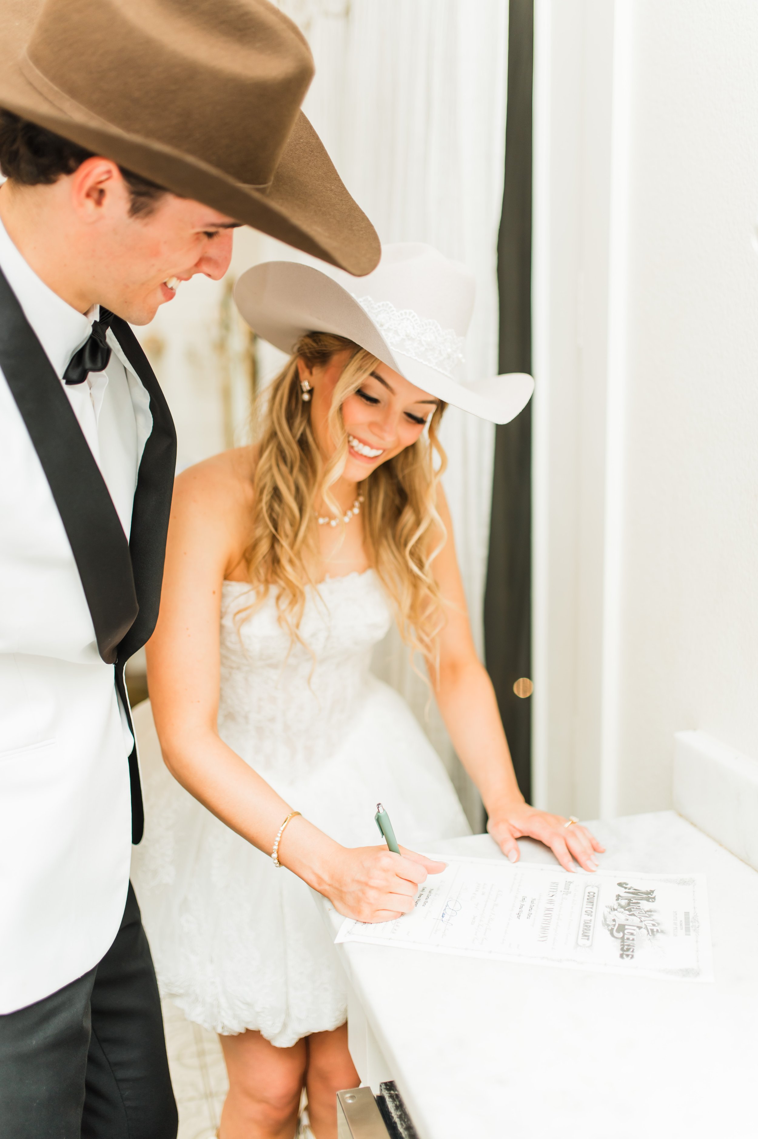 Bride and groom signing their marriage license at The French Farmhouse wedding venue in Collinsville, Texas
