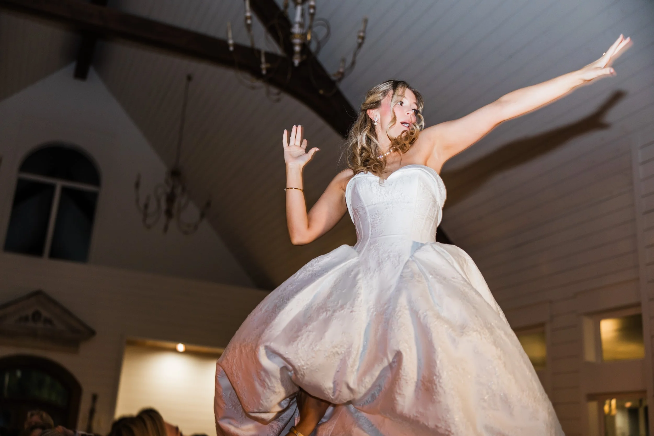 Bride in the air during wedding reception at the French Farmhouse Venue at Collinsville TX