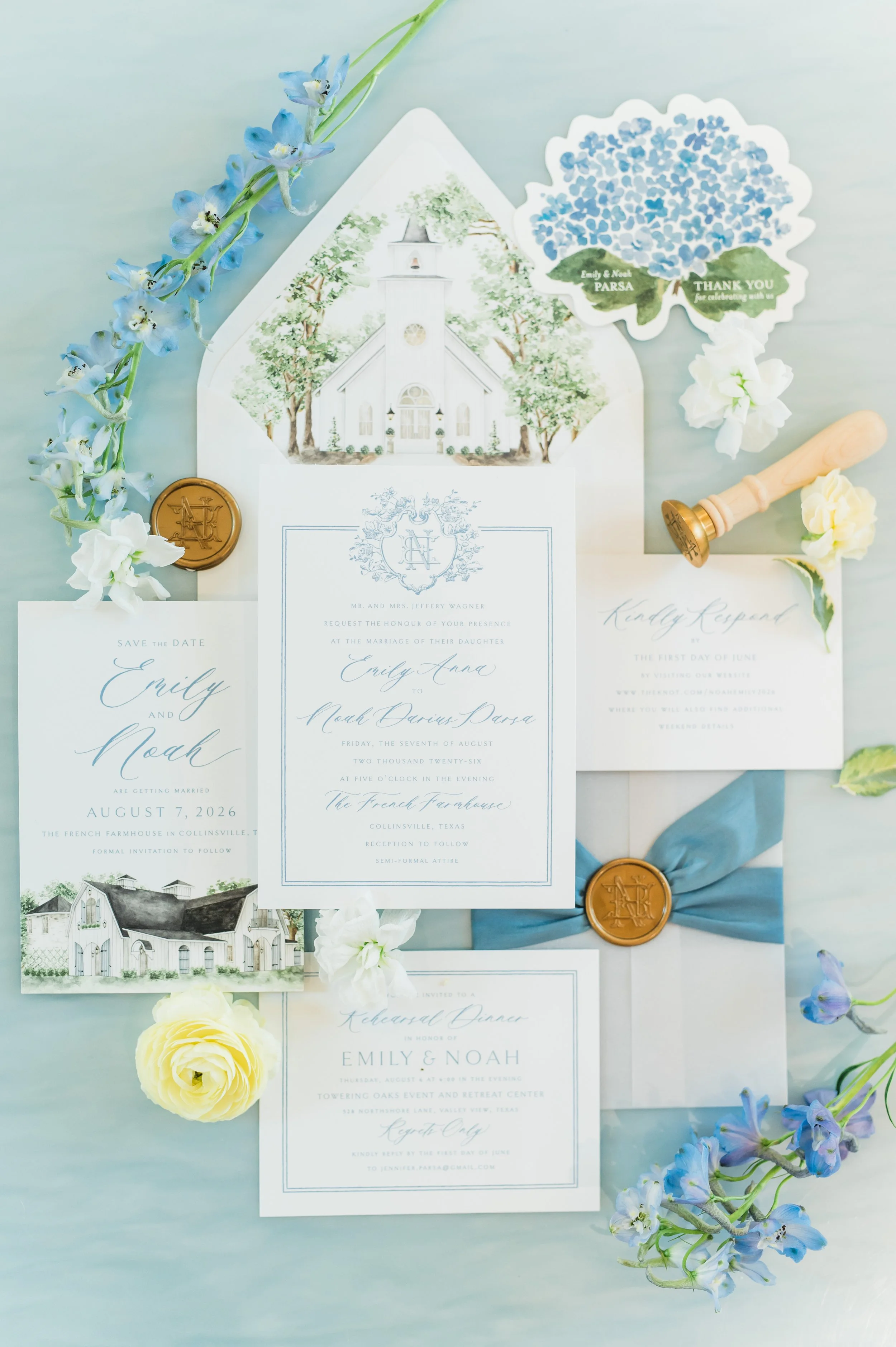Blue and white flatlay with invitation suite, florals, stamp, and custom envelope at the French Farmhouse Venue in Collinsville TX