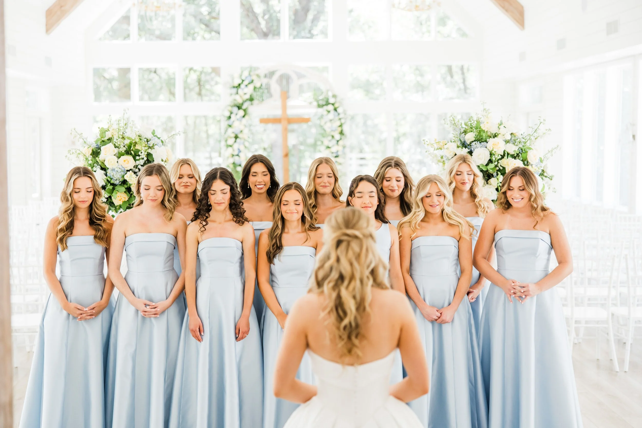 Bride's first look with her bridesmaids in the chapel at the french farmhouse venue in collinsville tx