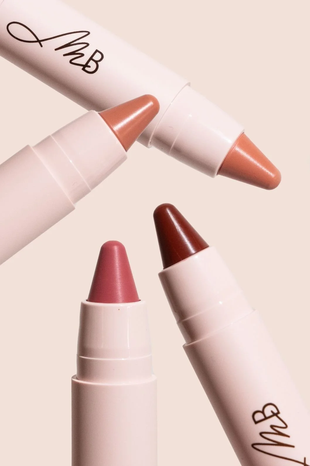 Makeup product photography of lipsticks in various colors angled towards the center as a minimal macro close up shot