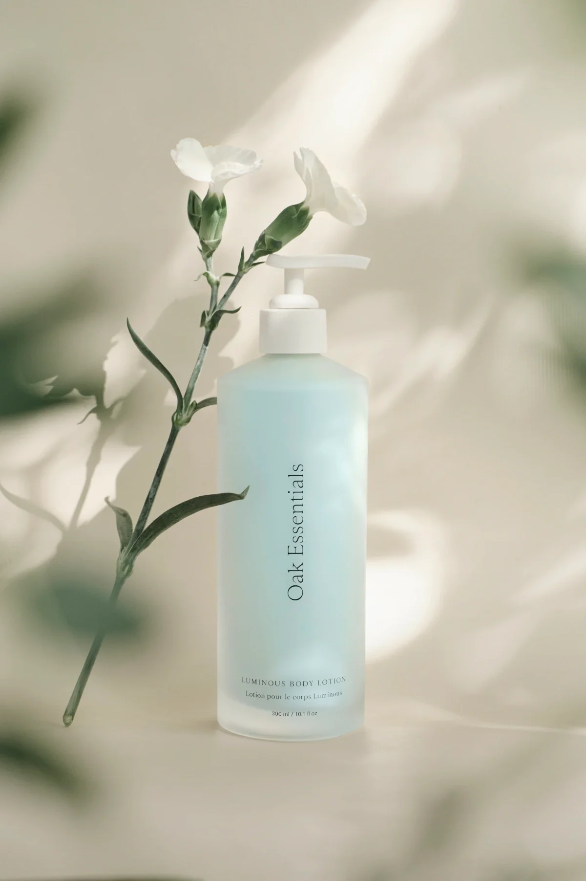 Skincare product photography of a blue bottle with blurred white flowers, beige background. Photo for e-commerce, campaigns, and marketing.