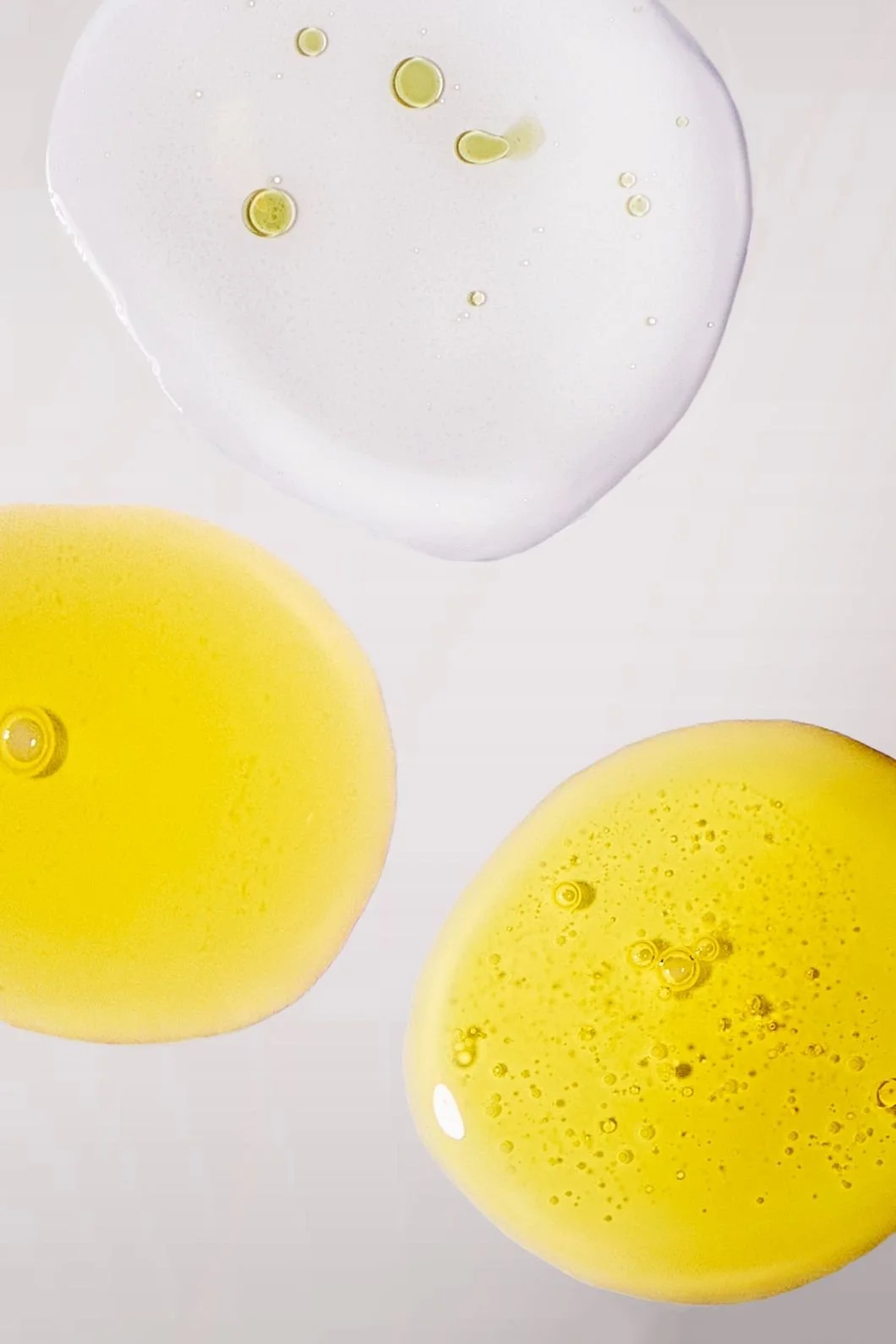Skincare photography of a serum, gel, and toner textures up closer on a grey background