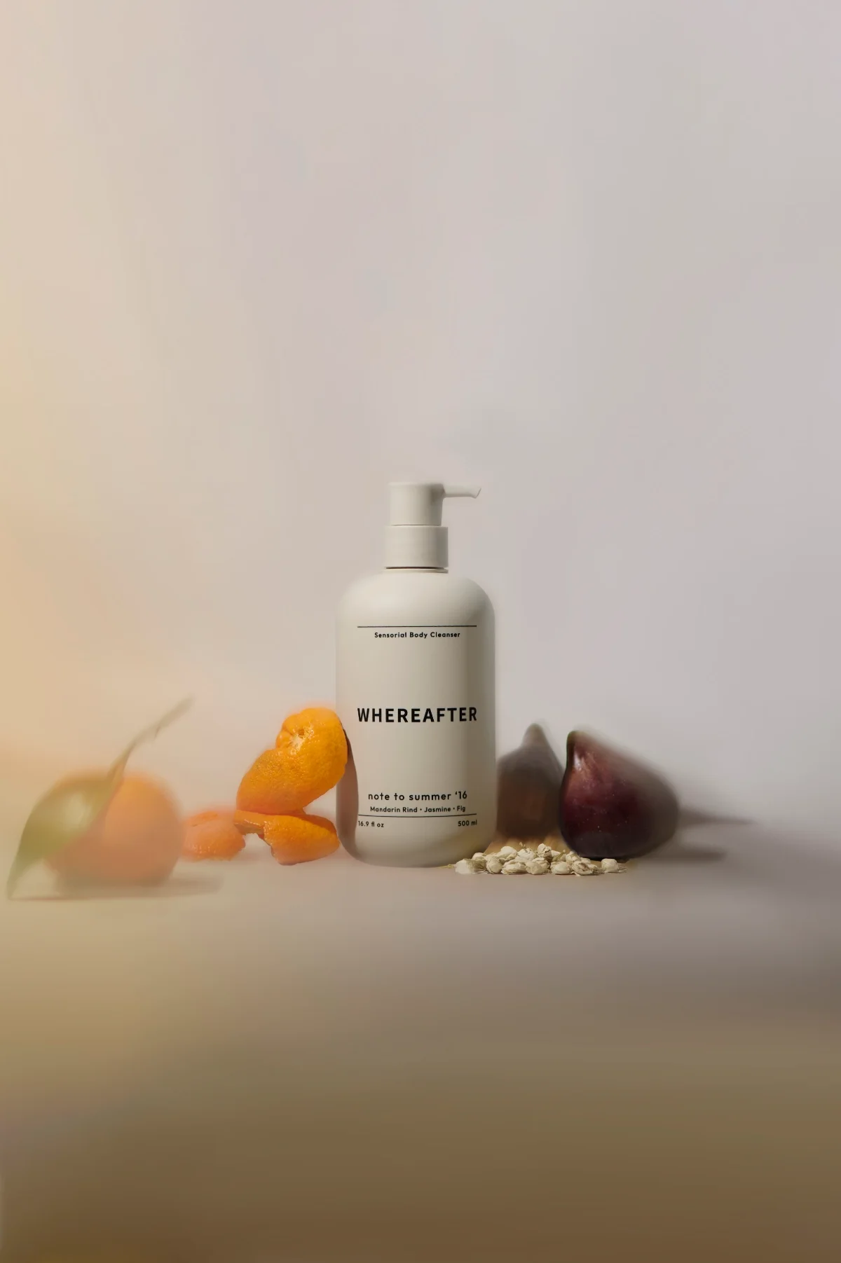 Skincare product photography of grey bottle with fruits and flowers, moody lighting. Photo content for e-commerce, campaigns, and marketing.