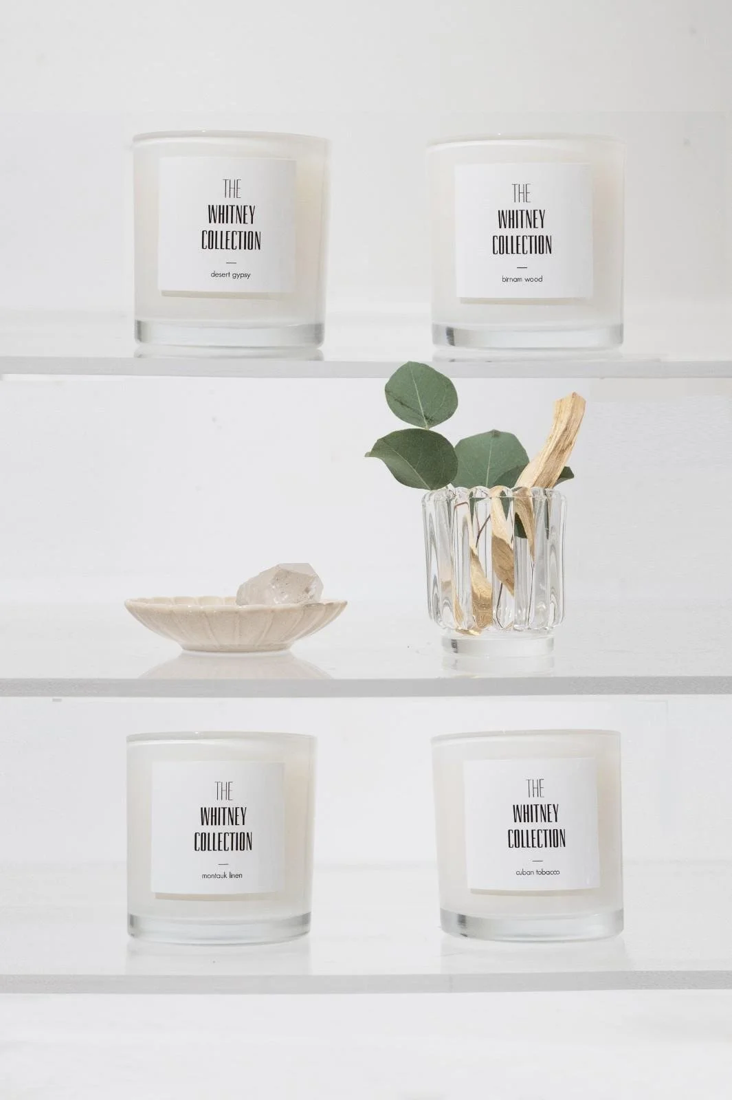 Seattle candle product photography of a white candles placed on clear glass shelves against a white background
