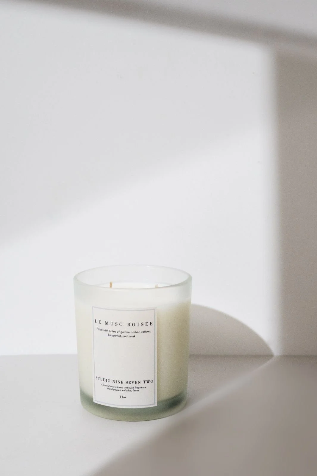 Seattle candle product photography of a white candle on a white background surrounded by dramatic shadows