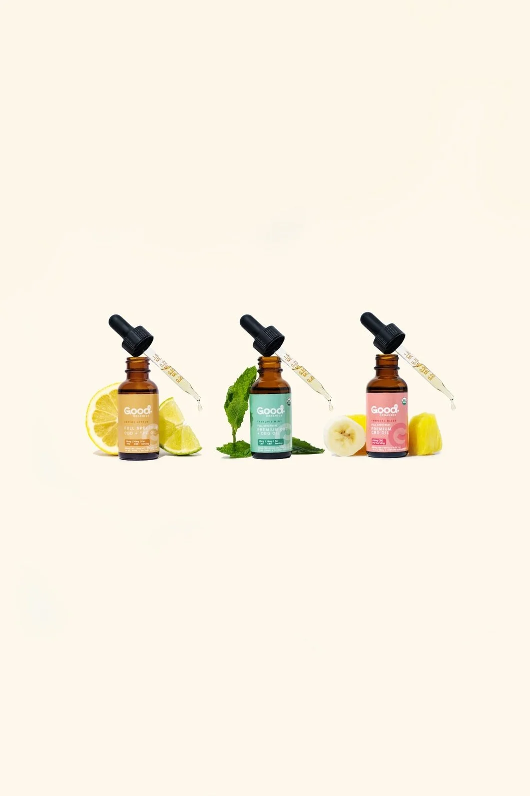 Seattle product photography of three CBD oils lined up in a row, each bottle surrounded by corresponding fresh ingredients