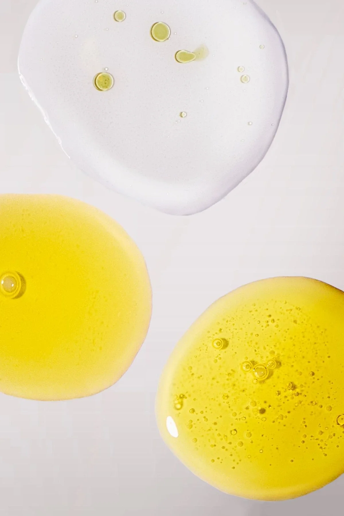 Skincare macro photography of a serum, gel, and toner textures up close on a grey background