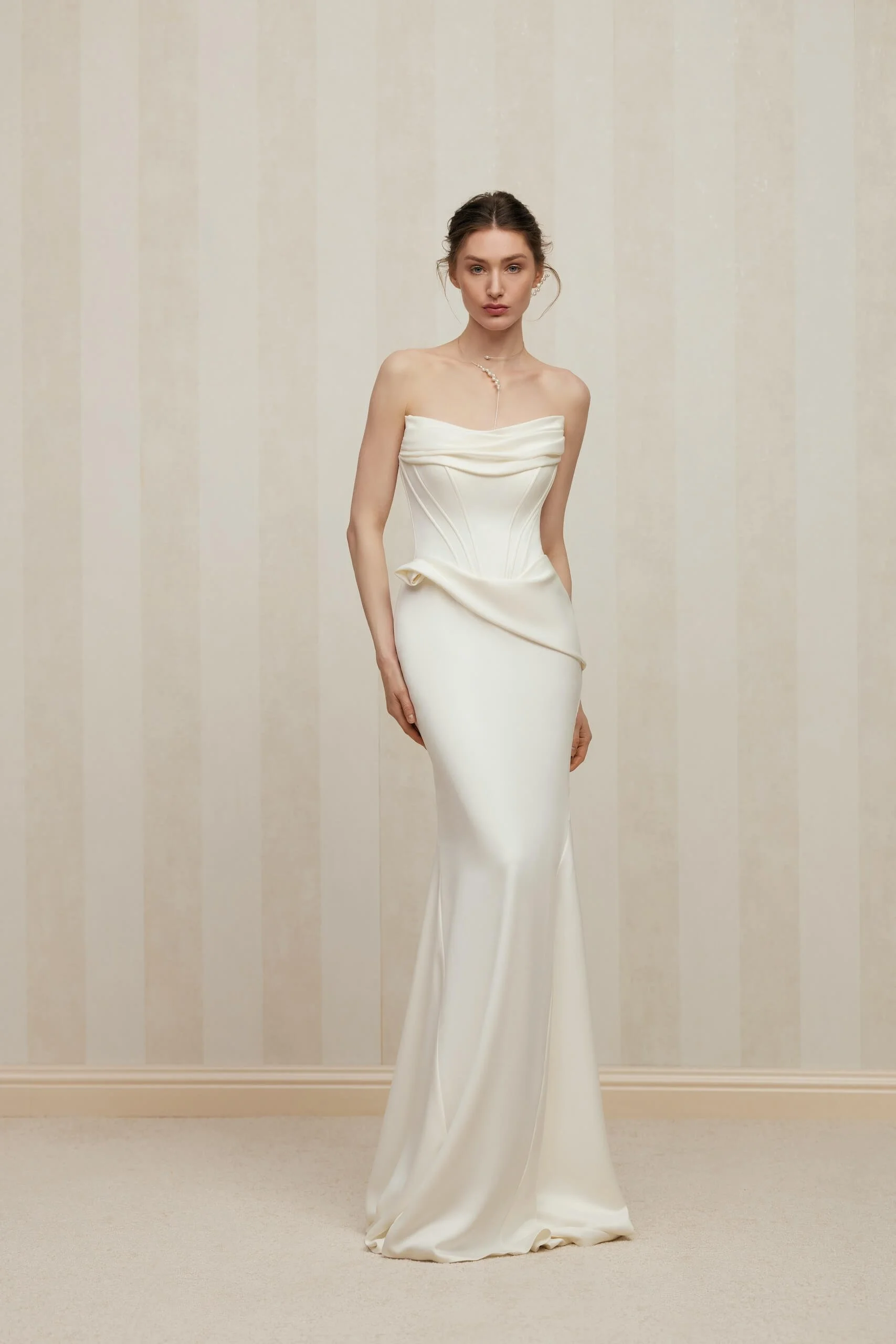 FENNA satin wedding dress by couture designer Anne-Mariée at Spellbound Bridal Ireland. A strapless fit and flare bridal gown featuring a softly draped straight neckline, structured corset bodice with sculpted seam detailing, an elegant draped waist 