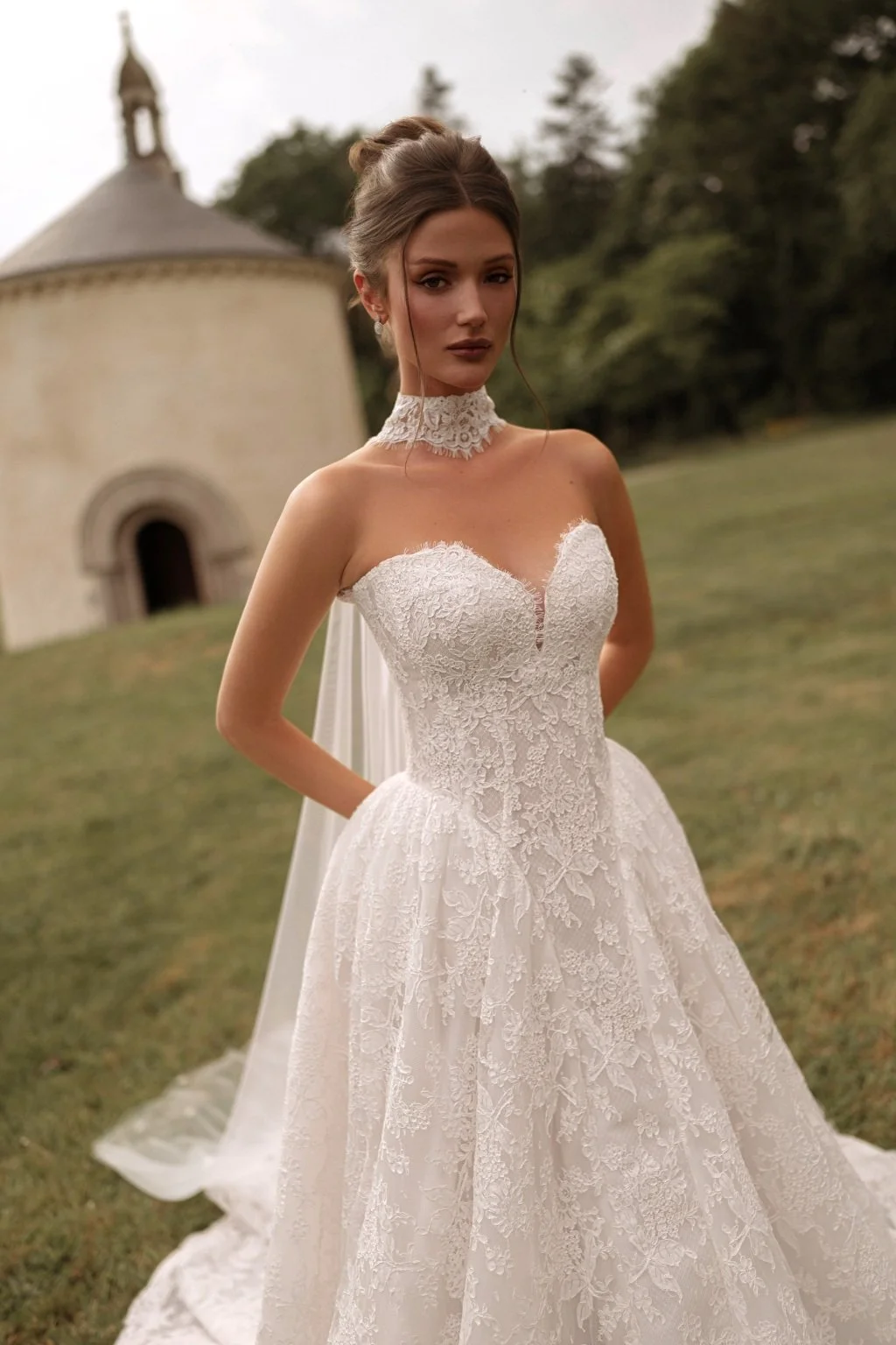 AVEL is a Chantilly lace ballgown style wedding dress. Brides can choose to complete their wedding day look with a lace choker that extends into a long cape-style train. Exclusively available at Spellbound Bridal, Wicklow, Ireland.
Dress Designer: Ka