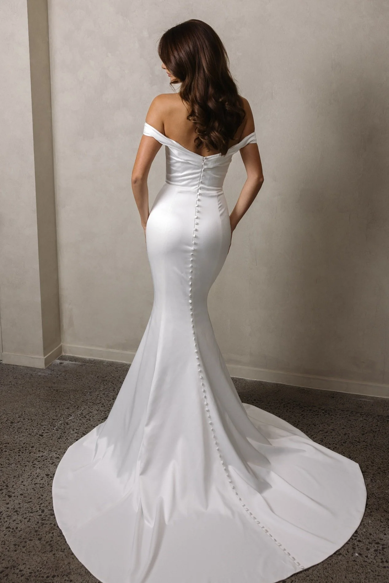 Lydia by Trish Peng satin wedding dress featuring a soft off-the-shoulder neckline, draped bodice, sculpted basque waist and fitted ruched skirt, available at Spellbound Bridal Ireland.