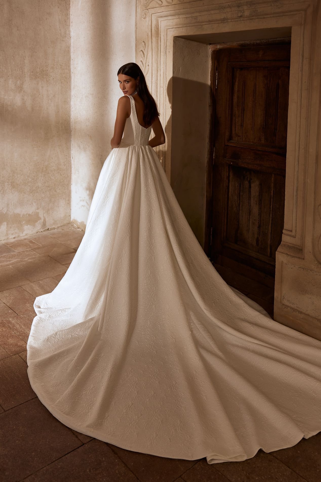 MARVIN is an exquisite square neckline princess ballgown wedding dress available in two luxury jacquard fabric variations. This textured look bridal gown with wide straps and a long train is classically elegant. Exclusively available at Spellbound Br
