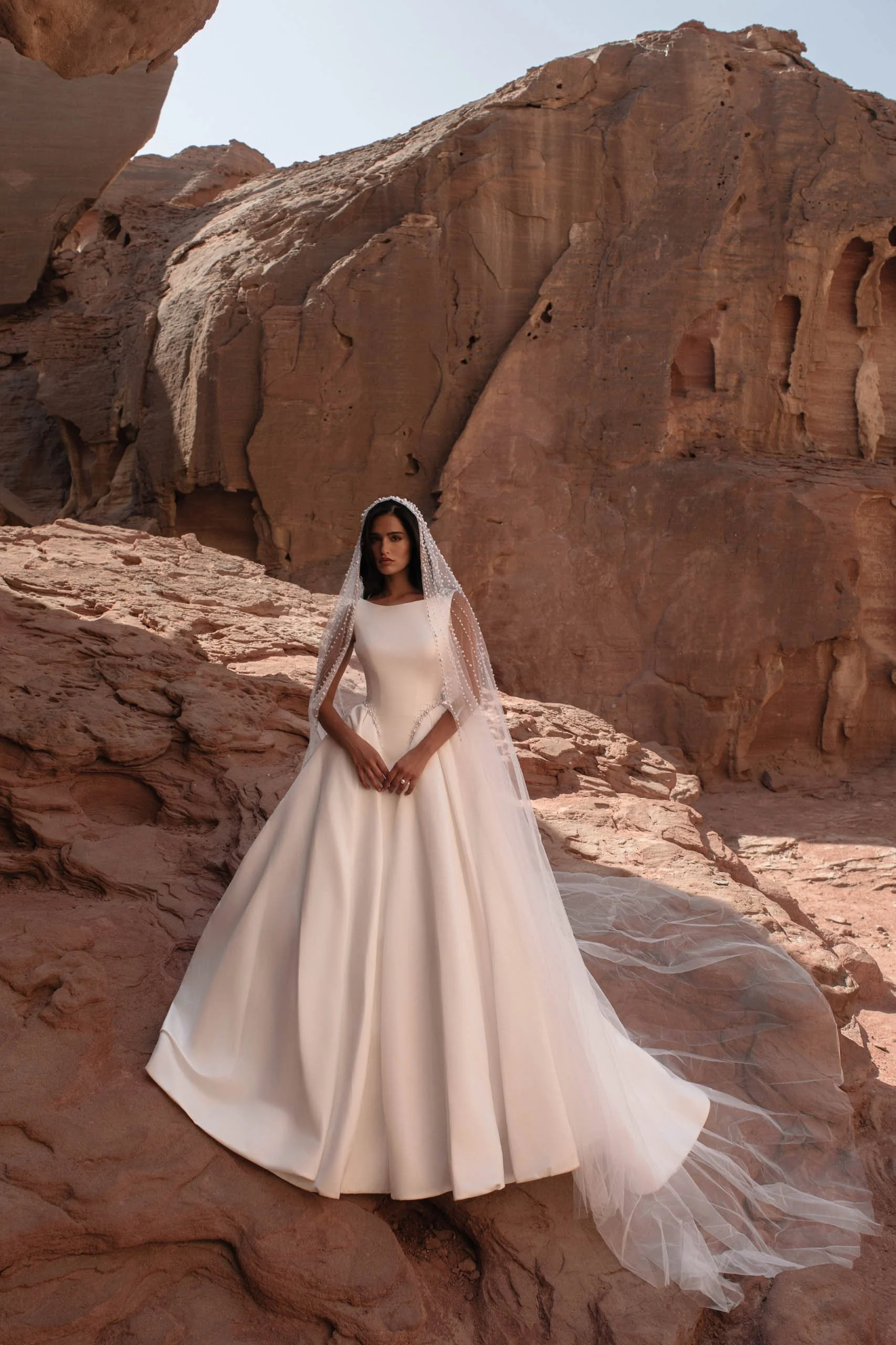 Discover Tori, a minimalist satin princess wedding dress with bateau neckline, structured corset, pearl waist detail and hidden pockets. Available at Spellbound Bridal Ireland.