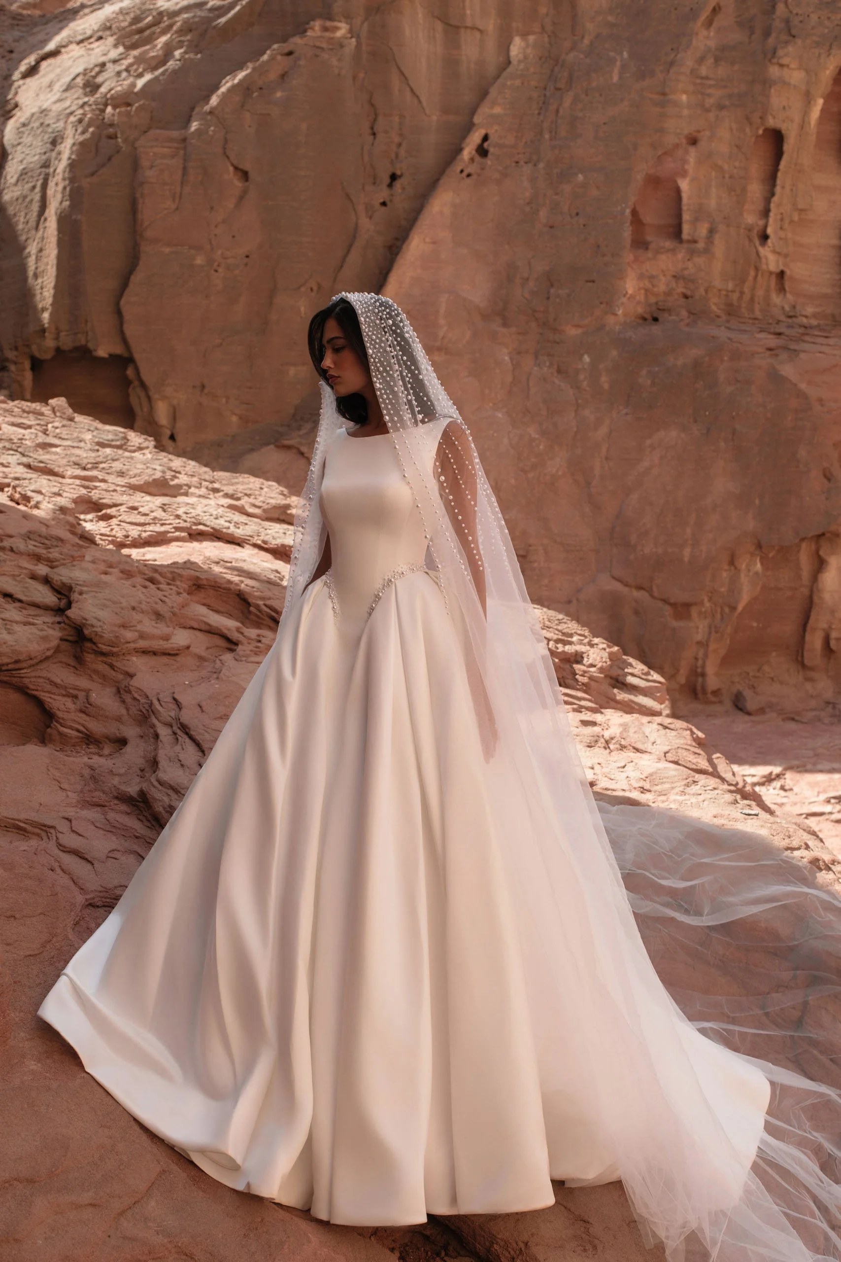 Discover Tori, a minimalist satin princess wedding dress with bateau neckline, structured corset, pearl waist detail and hidden pockets. Available at Spellbound Bridal Ireland.