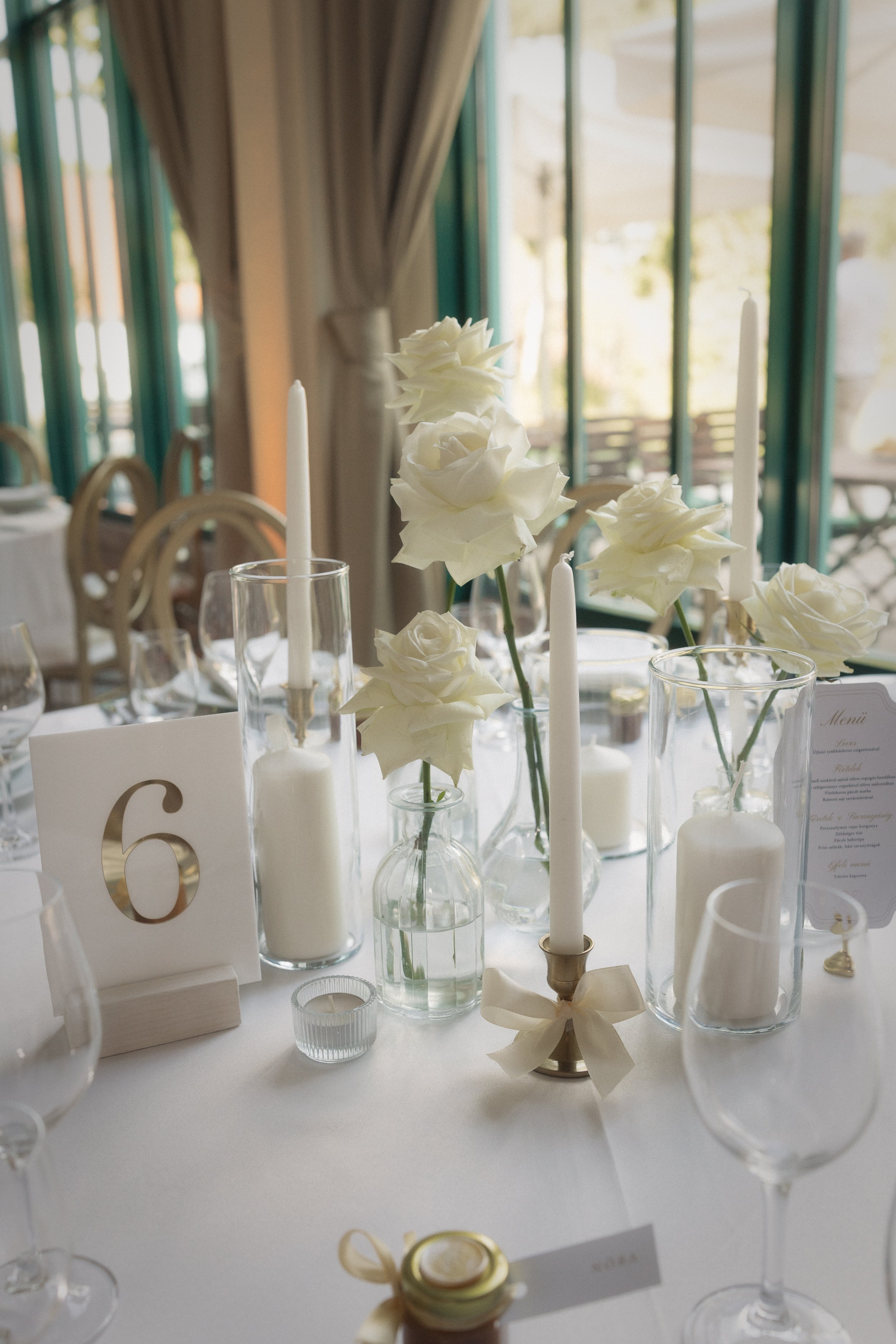 Esküvői ültetési rend elegáns állványon fehér virágdekorral - vendégirányító tábla a tatai Pálma Rendezvényház esküvőjén, MONA Design dekoráció