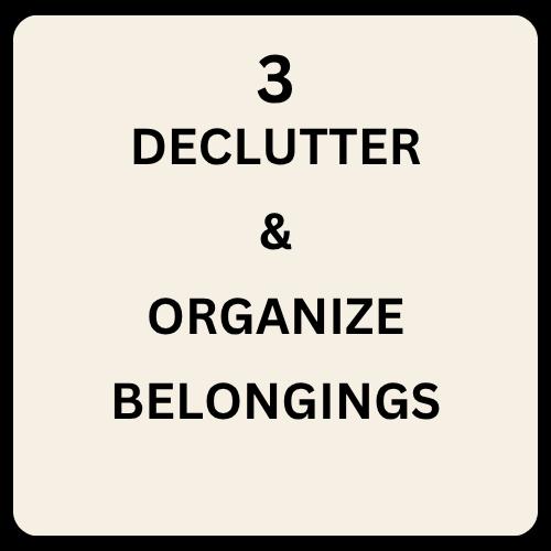 A sign with the message: '3 Declutter & Organize Belongings' in black text on a white background.