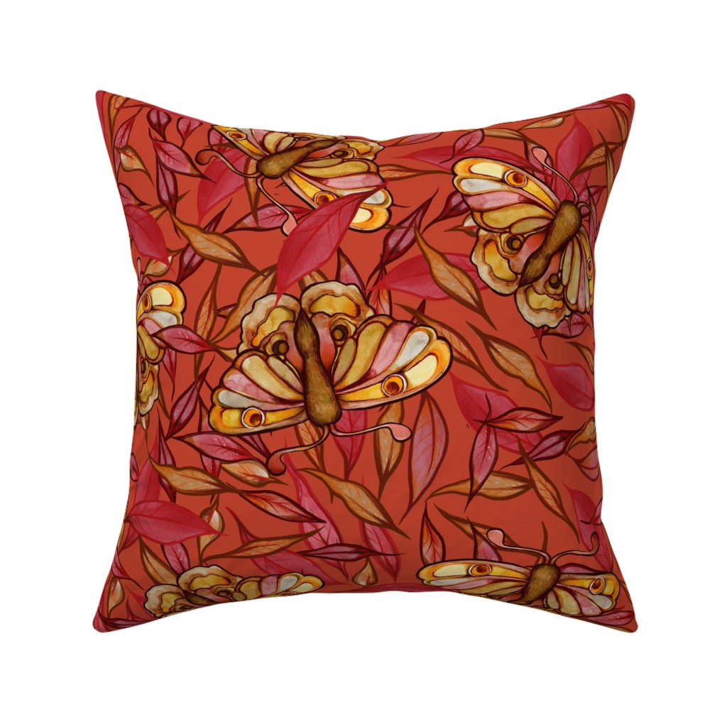 A decorative square pillow with a red-orange background featuring a pattern of yellow and orange butterflies and reddish leaves.