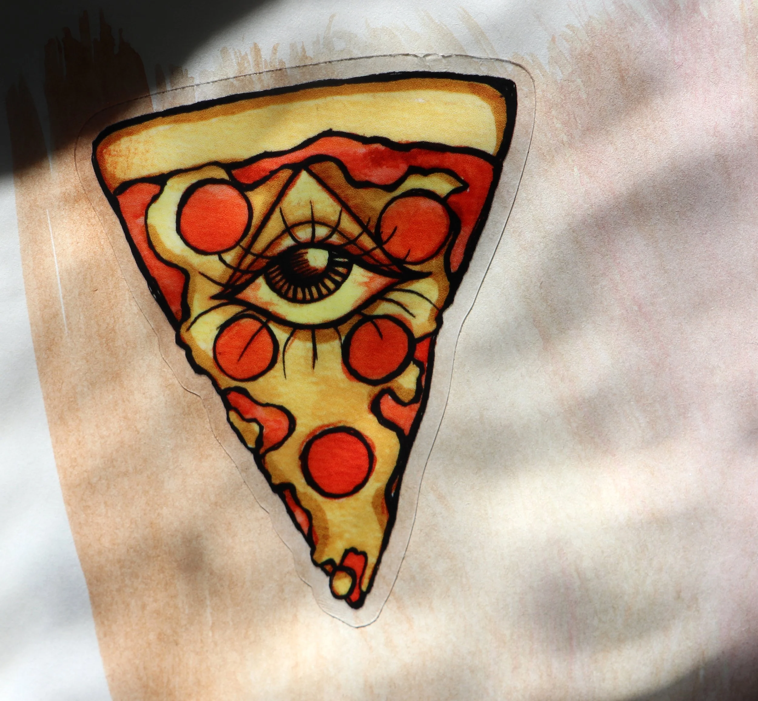 Colorful hand-drawn pizza slice with toppings and black outlines on a piece of paper.