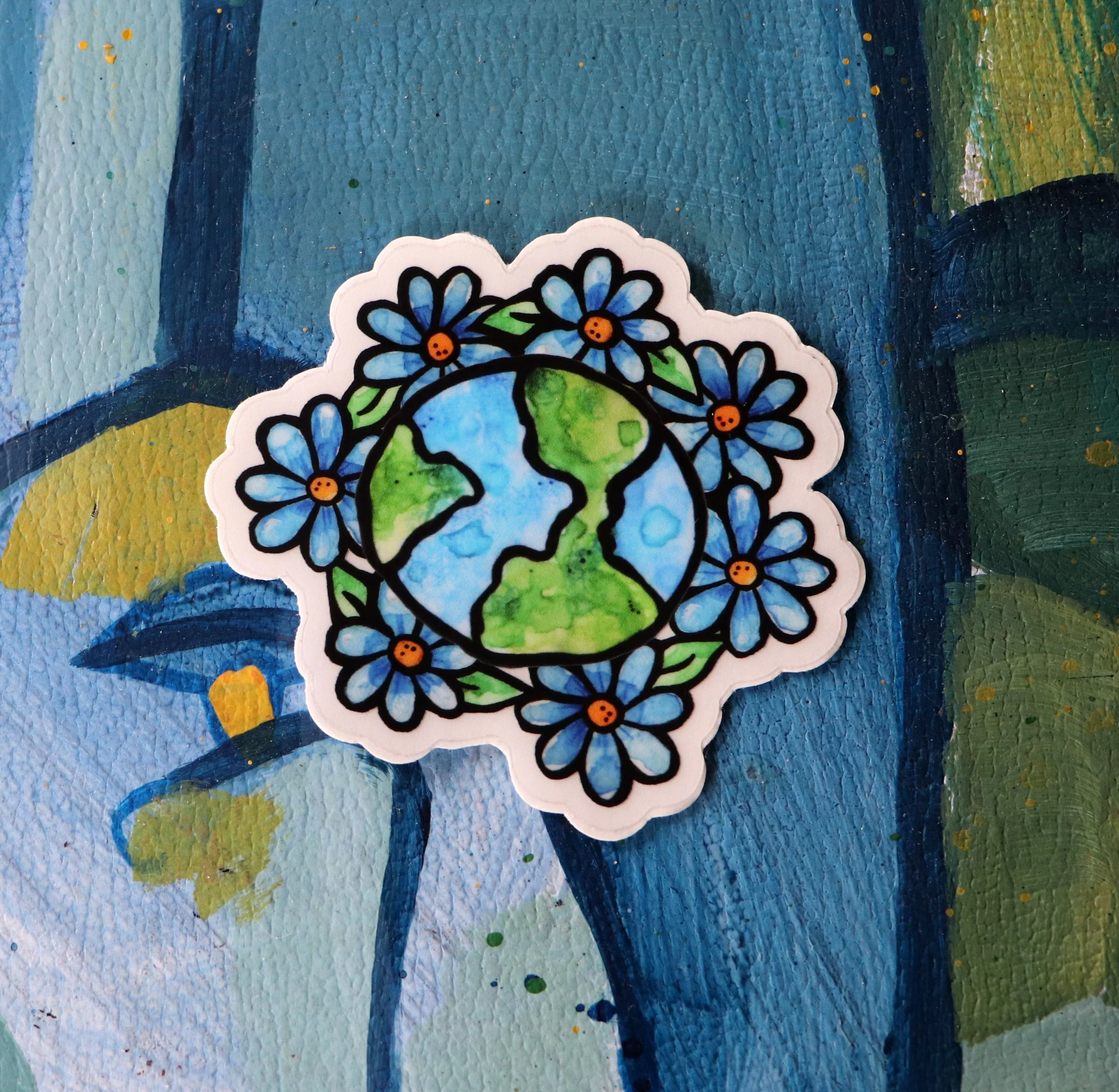 Close-up of a colorful sticker with a floral design on a textured, painted background.