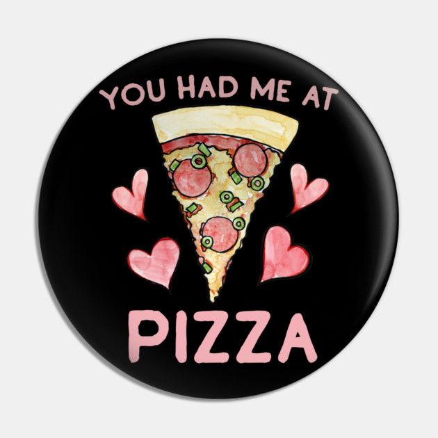 Black circular badge with a drawing of a pizza slice at the center, surrounded by pink hearts. Pink text above and below the pizza slice reads, "You had me at Pizza."
