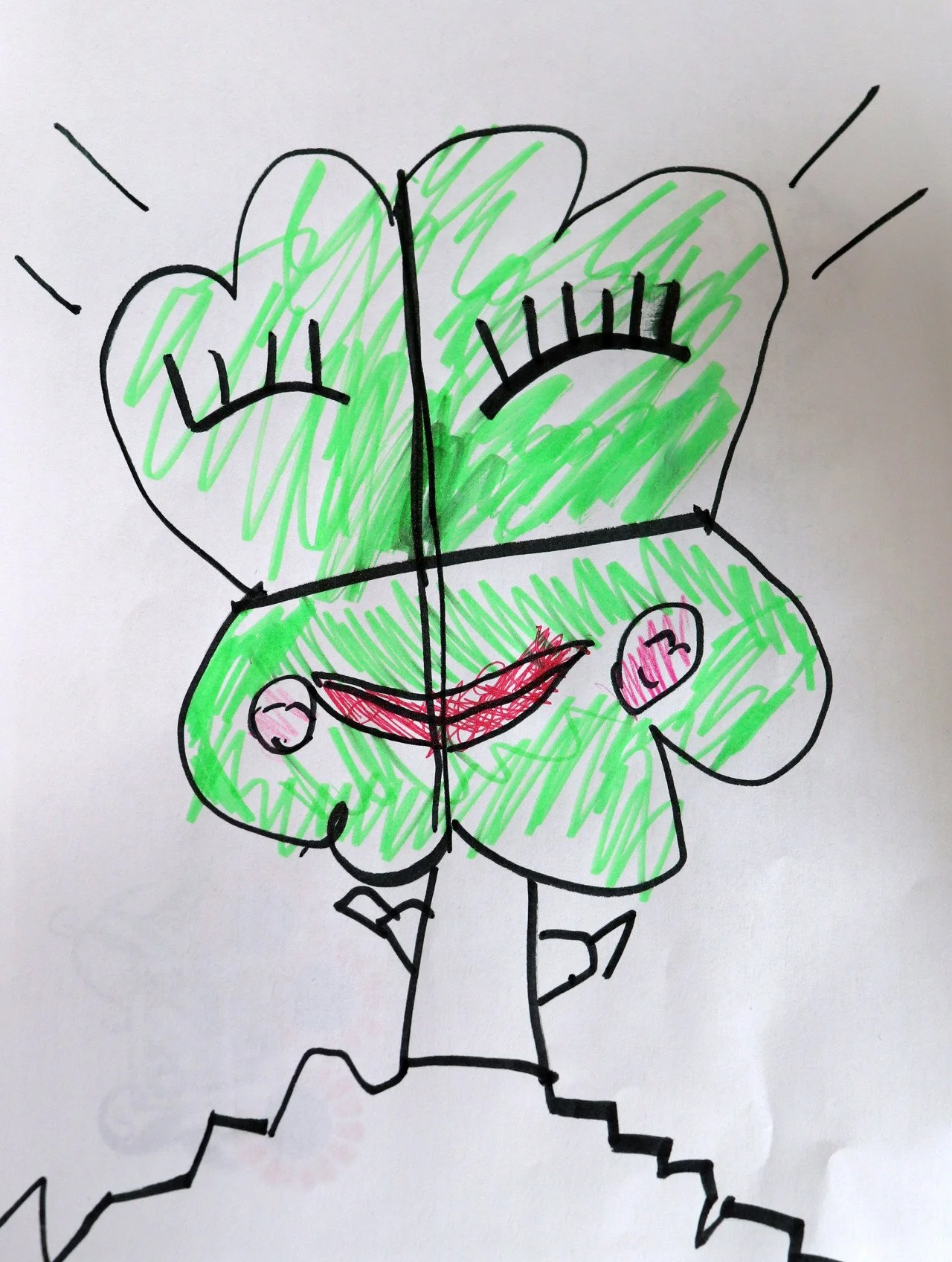 Child's drawing of a smiling person with closed eyes, surrounded by green and pink, with rays extending outward.
