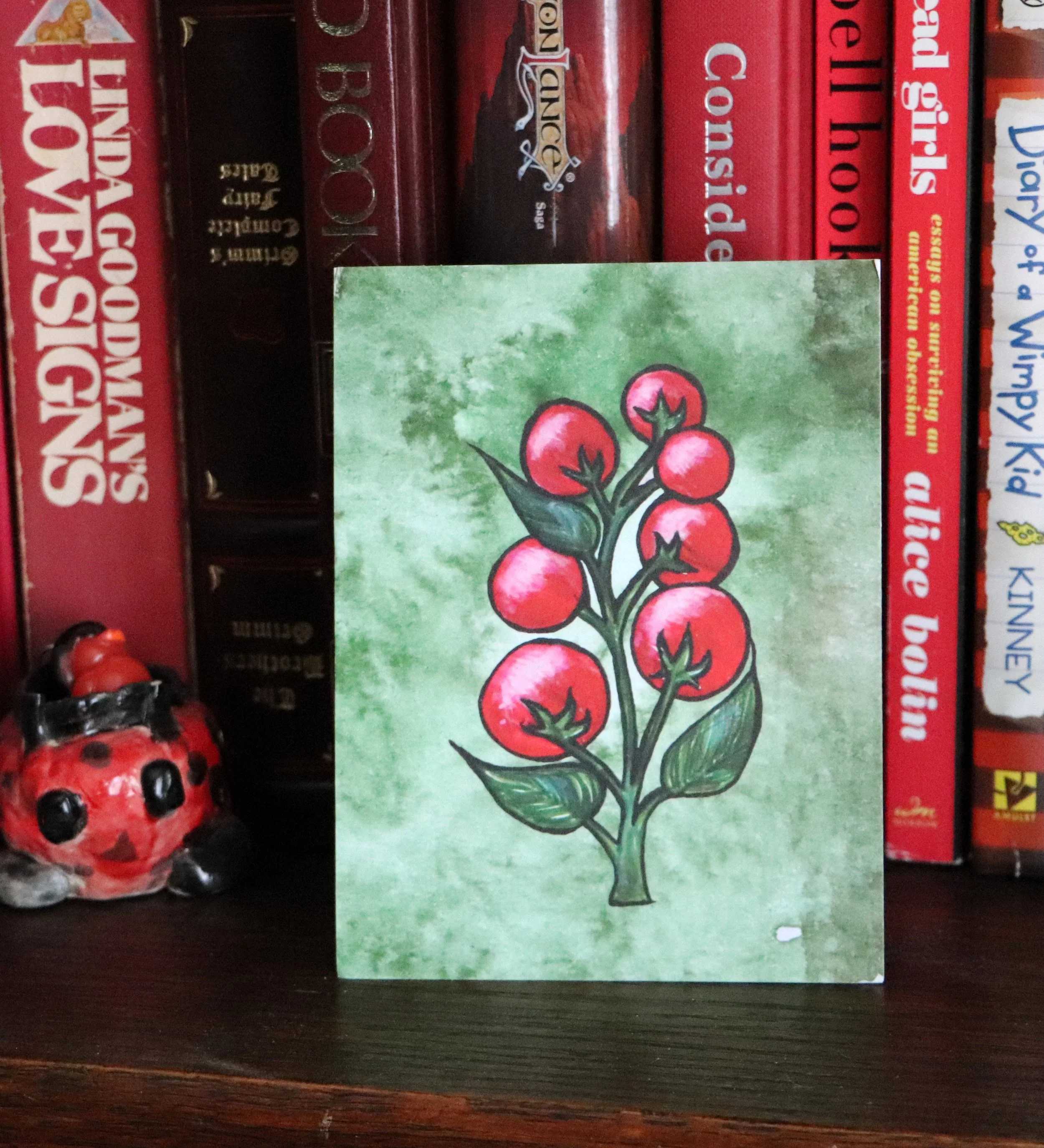 A bunch of small tomatoes on a branch with green leaves on a textured green background.