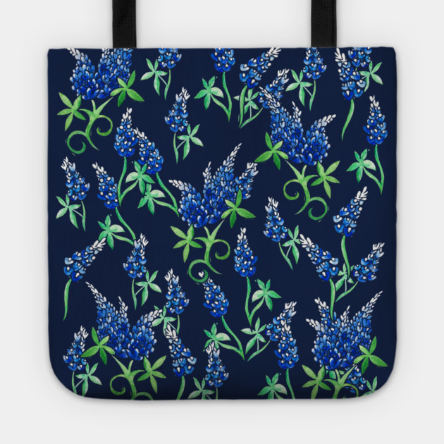 A fabric tote bag with a navy blue background featuring a pattern of blue and texas bluebonnet  flowers and green leaves.