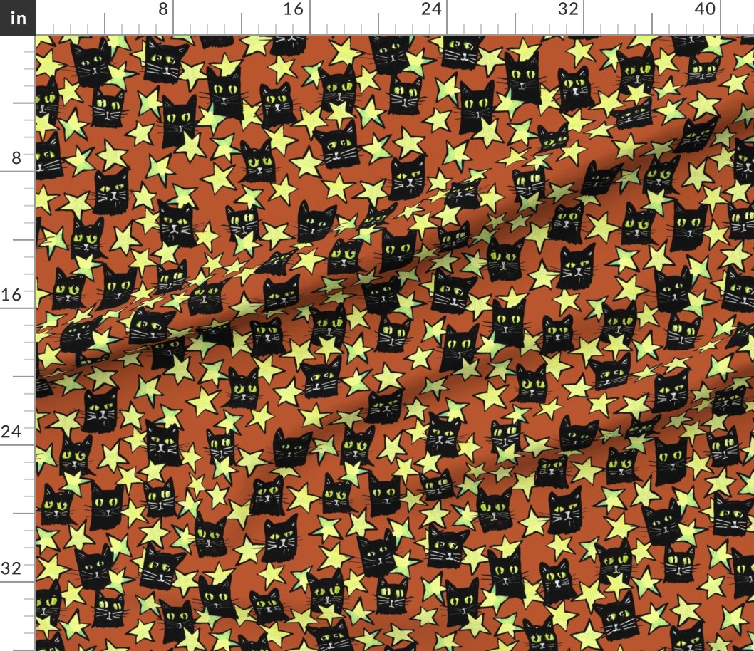 Pattern of black cat faces with green eyes and white whiskers, yellow stars, and an orange background.