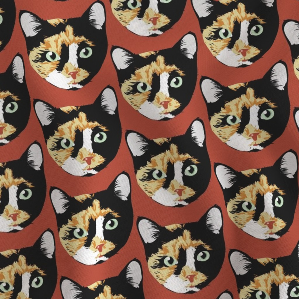 Pattern featuring cat faces with calico coloring, green eyes, and black markings on a rust-colored background.