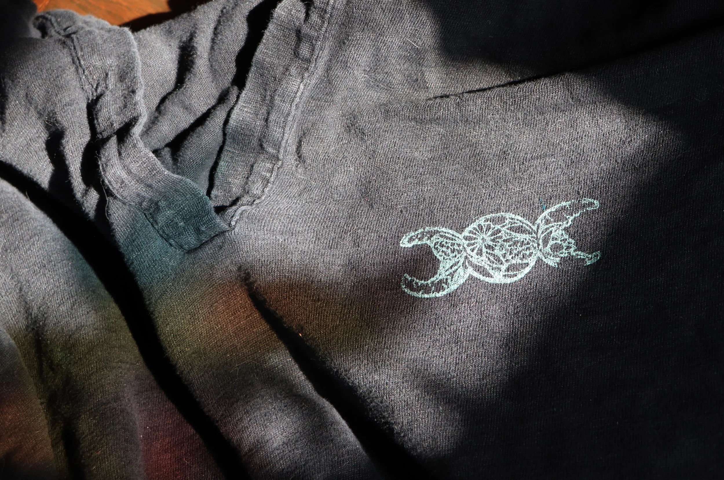 Close-up of a gray fabric with a small embroidered turtle design.