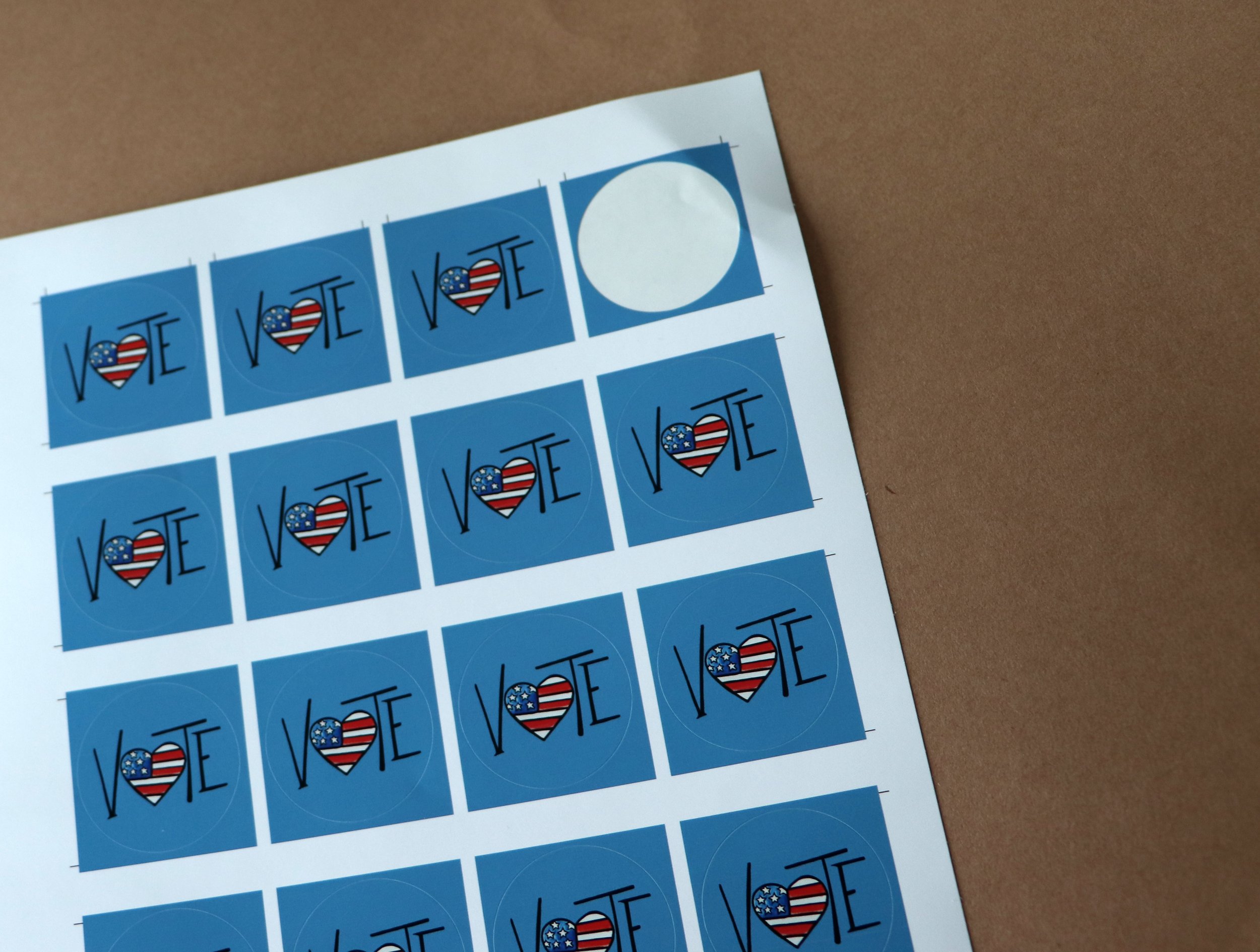 Sheet of blue voting stickers with the word 'VOTE' and a heart shape filled with the American flag.