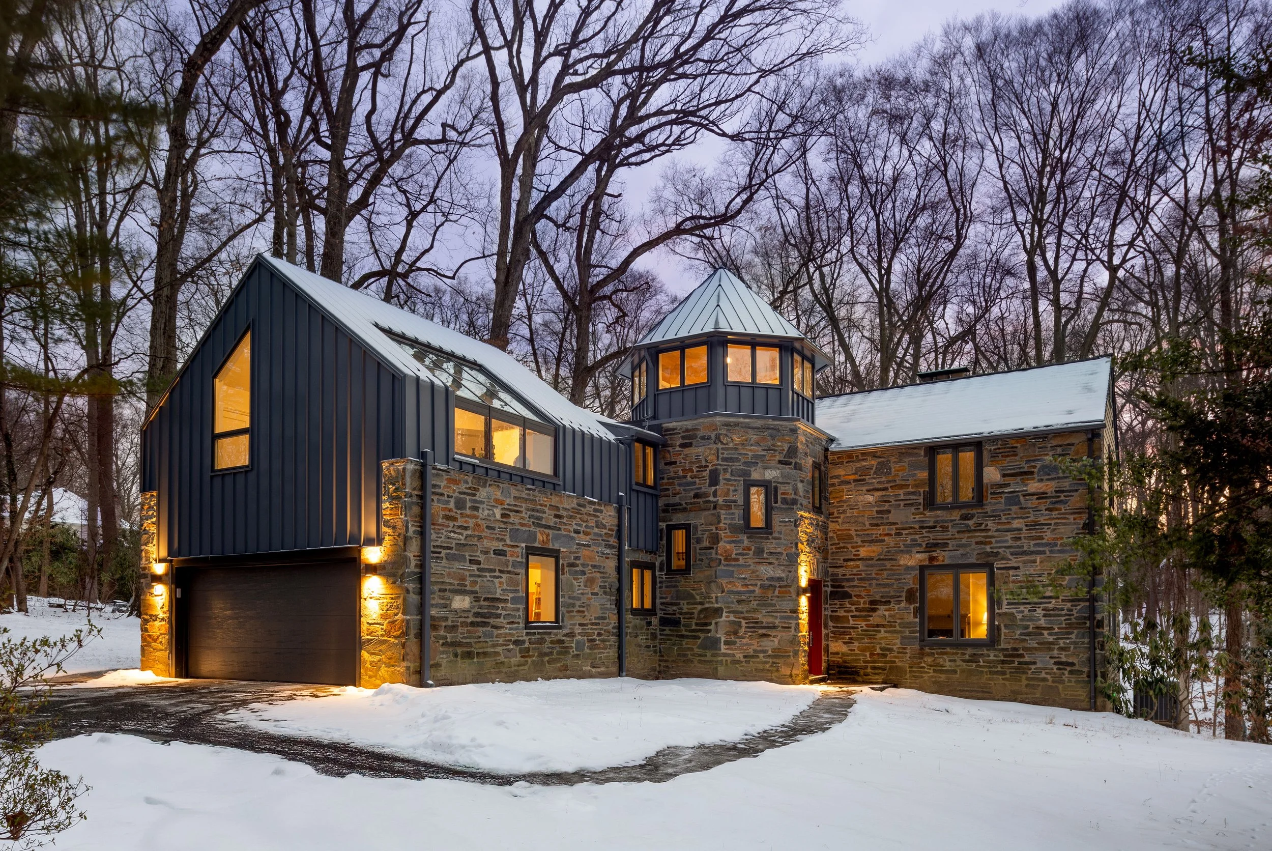 Modern tudor stone house with turret clerestory windows main line home