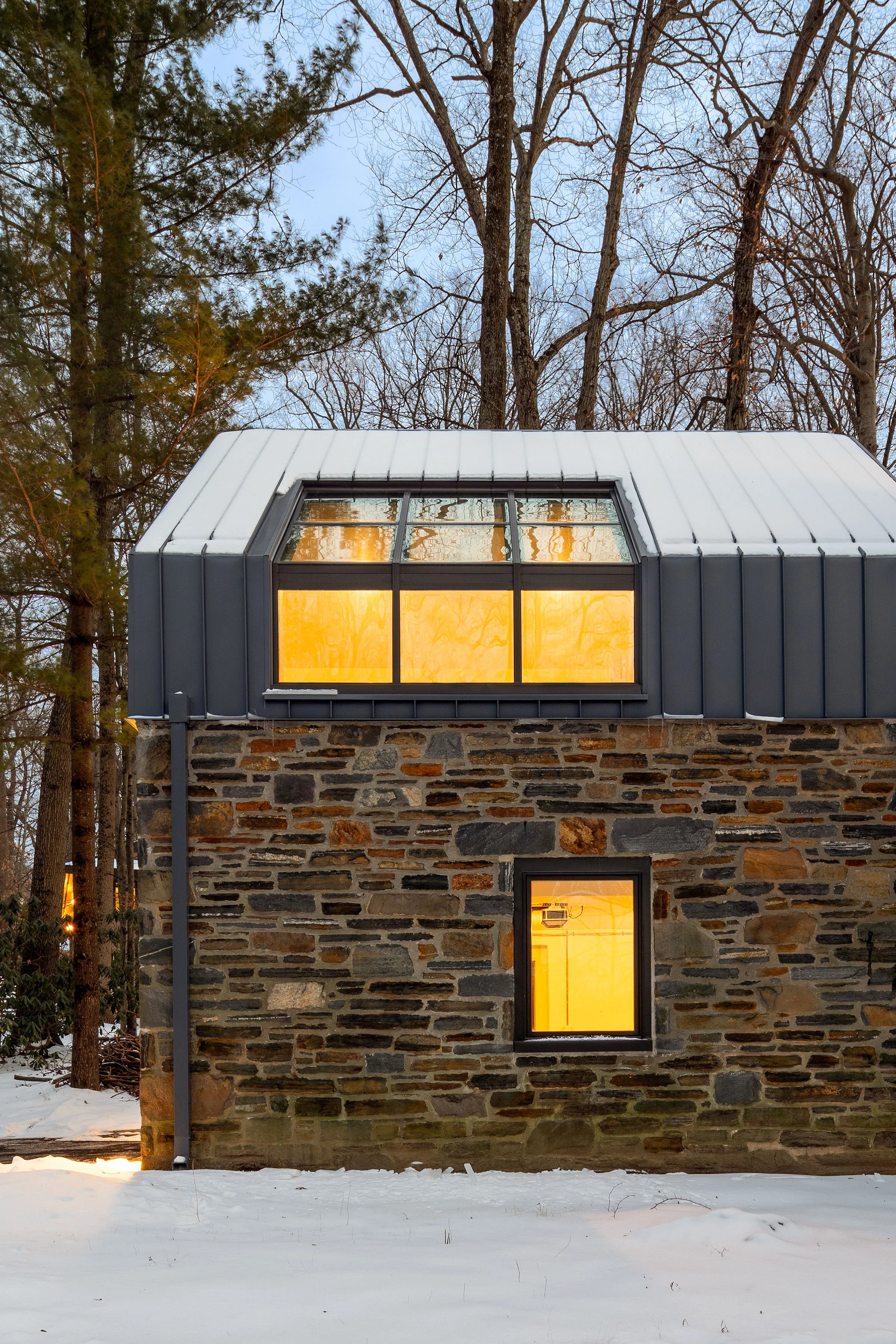 Modern tudor stone house with turret clerestory windows main line home