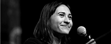 Close-up of a smiling woman holding a microphone, black and white photo