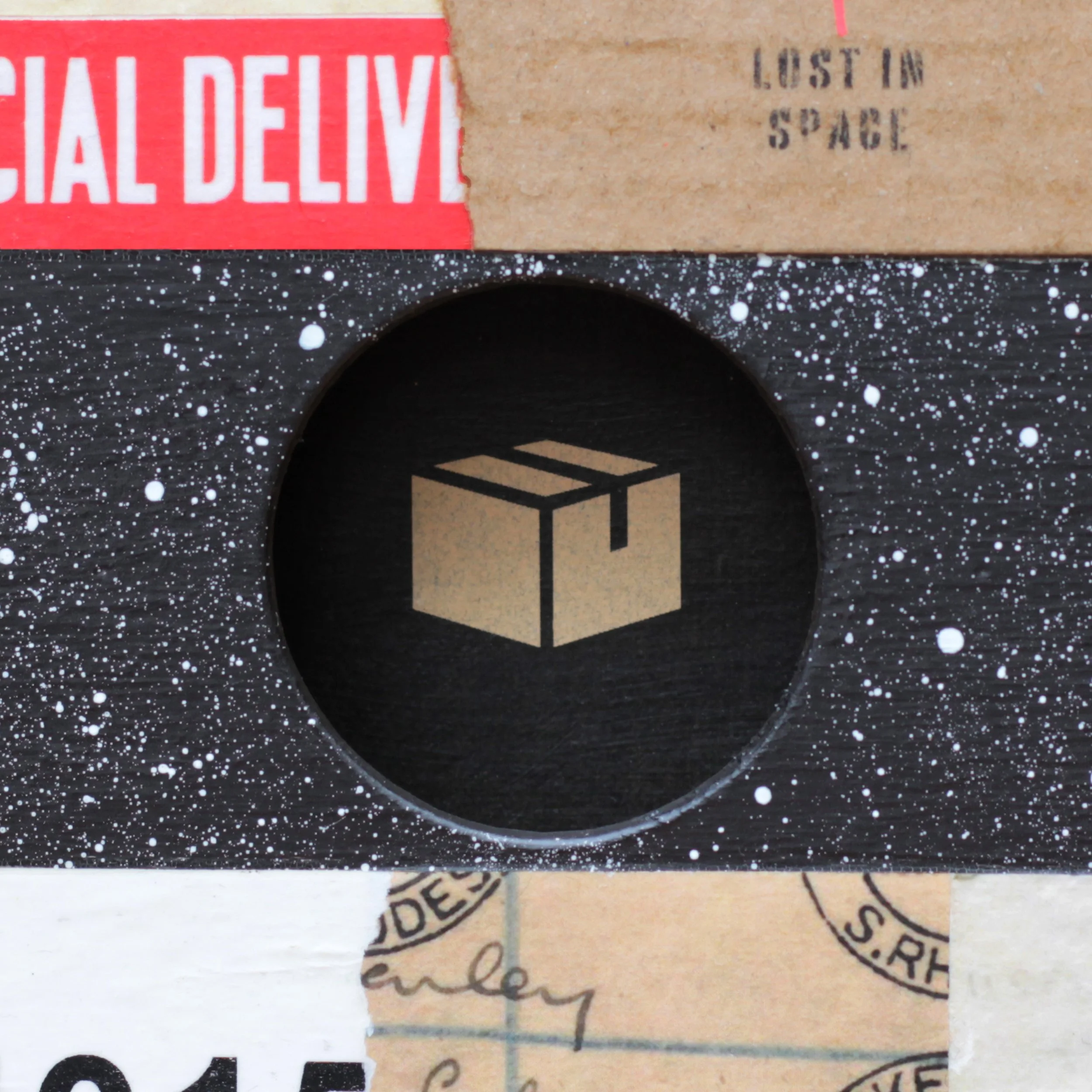 A sticker of a cardboard box inside a circle, with a black background and white paint splatter pattern surrounding it.