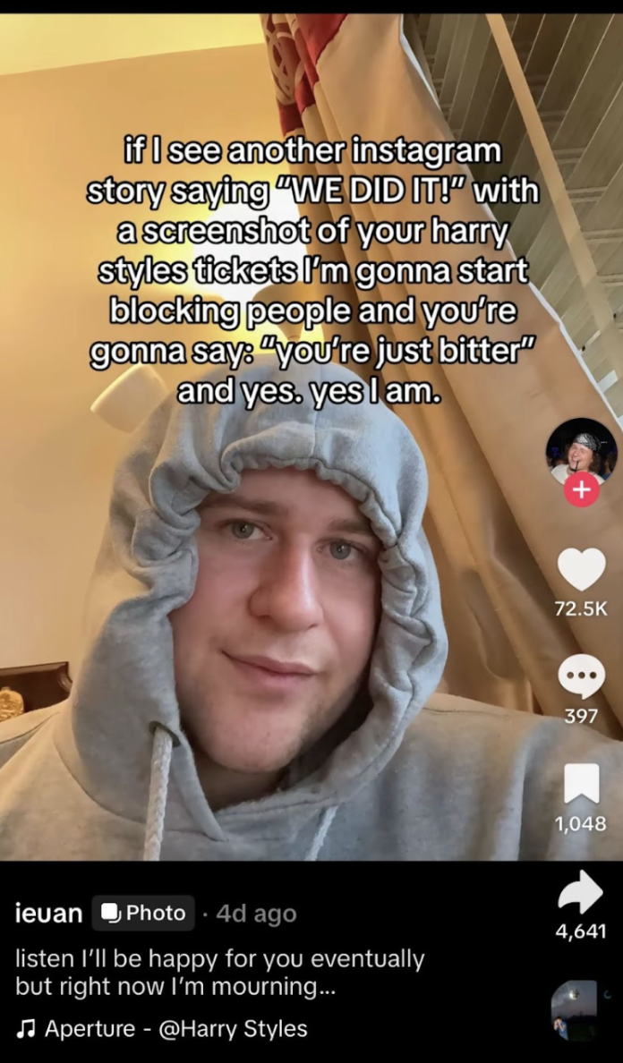 A man sits behind text reading "If I see another Instagram story saying We Did It with a screenshot of your Harry Styles tickets I'm gonna start blocking people. And you're gonna say you're just bitter and yes. Yes I am."