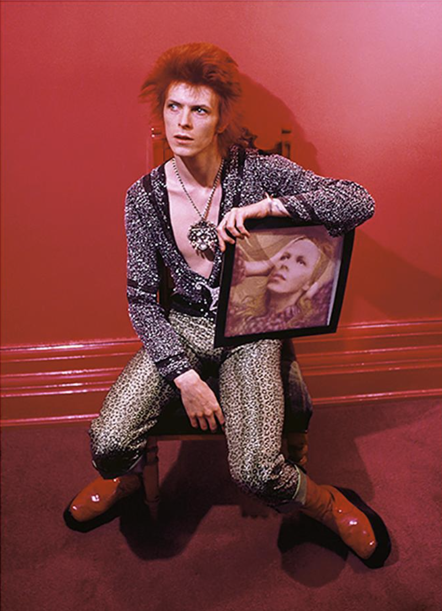 David Bowie as Ziggy Stardust holding the Hunky Dory album cover