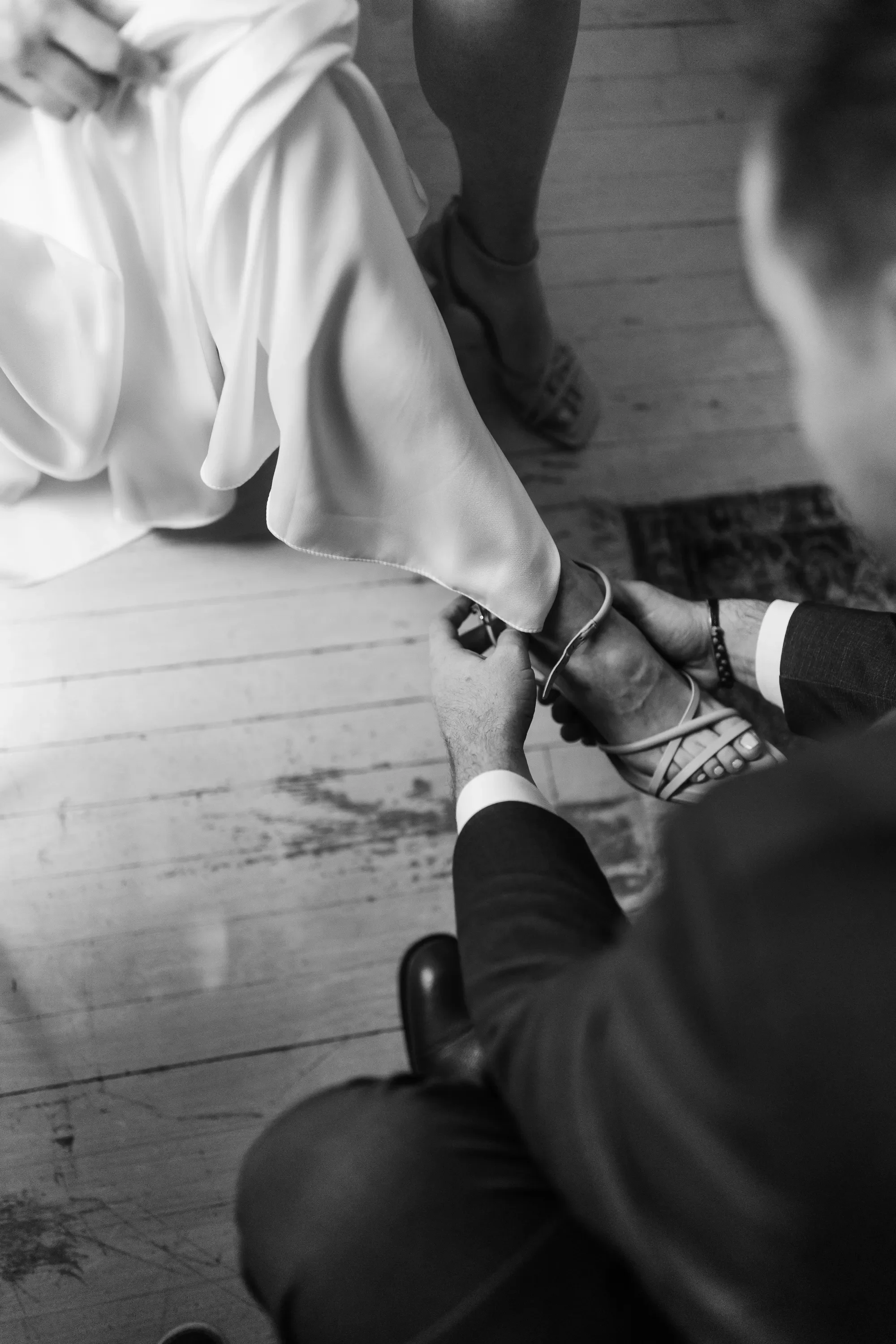 04-hands-fastening-ankle-strap-overhead-bw-pilgrim-chapel-kansas-city.webp