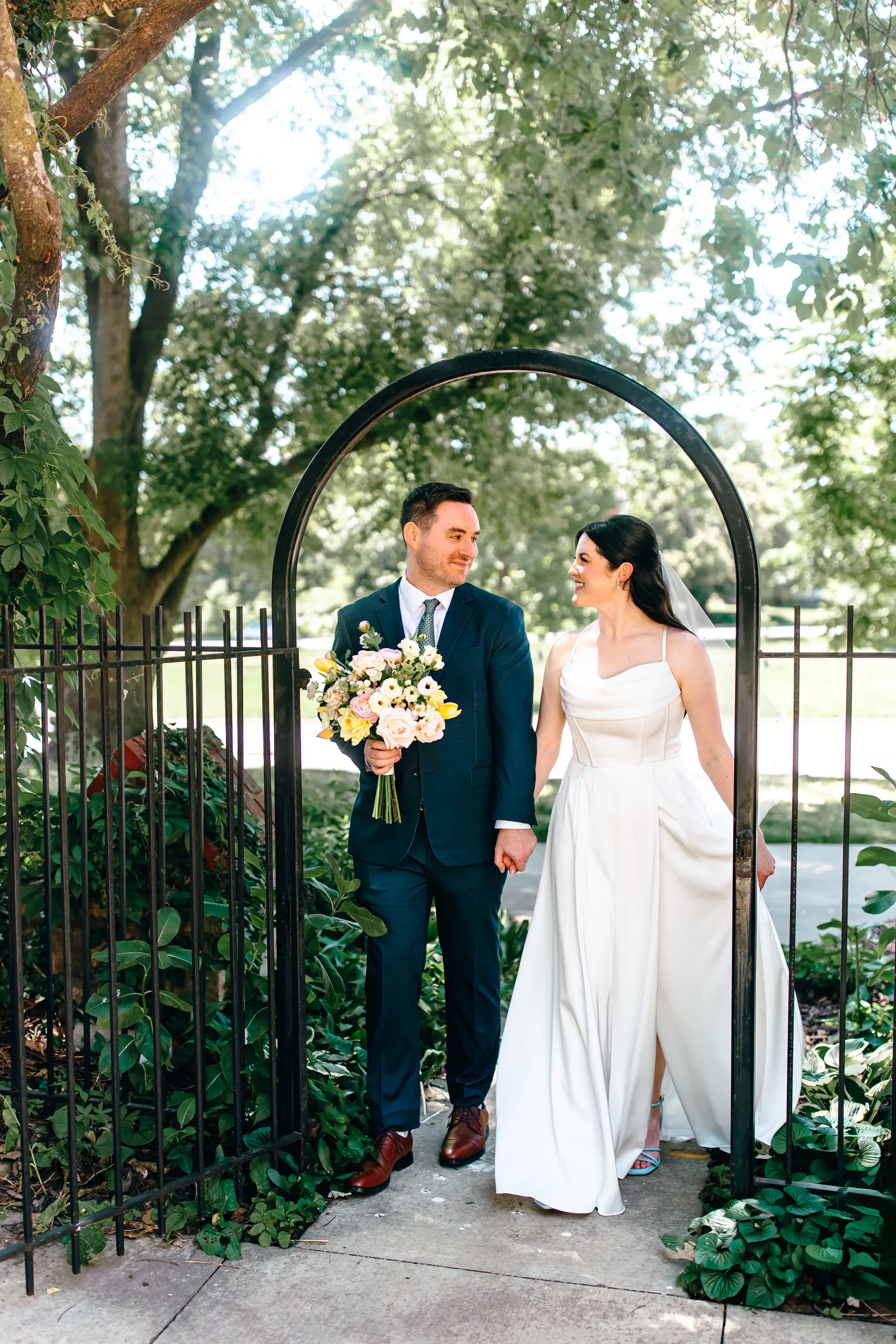 09-couple-under-iron-garden-arch-pilgrim-chapel-kansas-city.webp