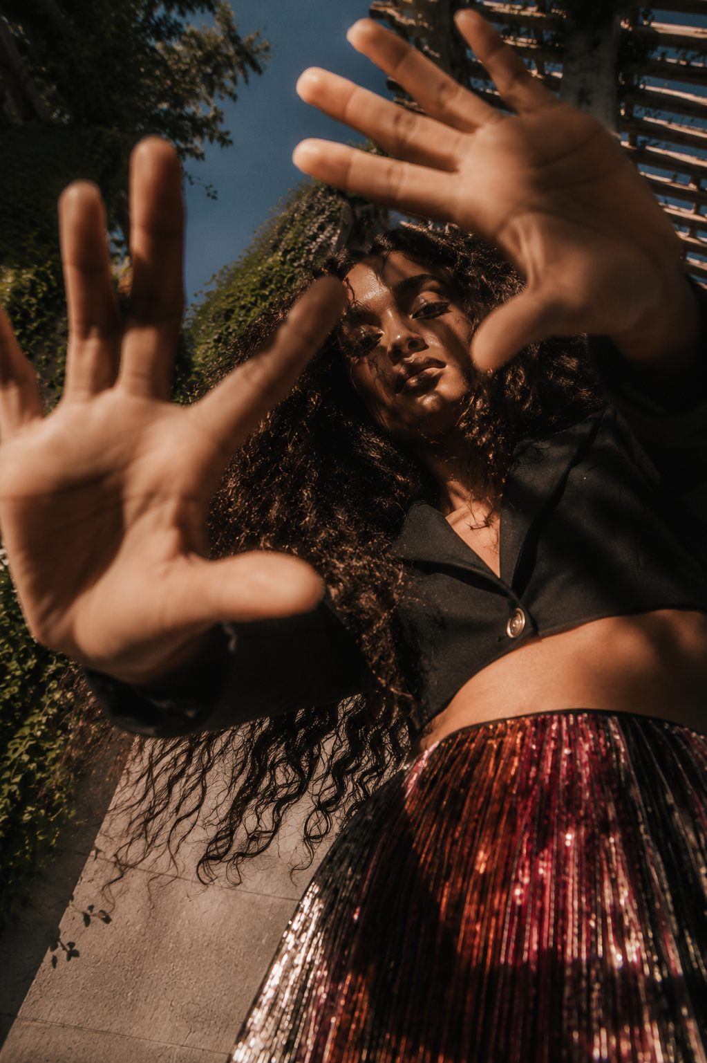 AI-created fashion campaign image for THE OUTNET by Alessia Moccia in São Paulo, featuring a woman in a black cropped jacket and shimmering Missoni skirt.