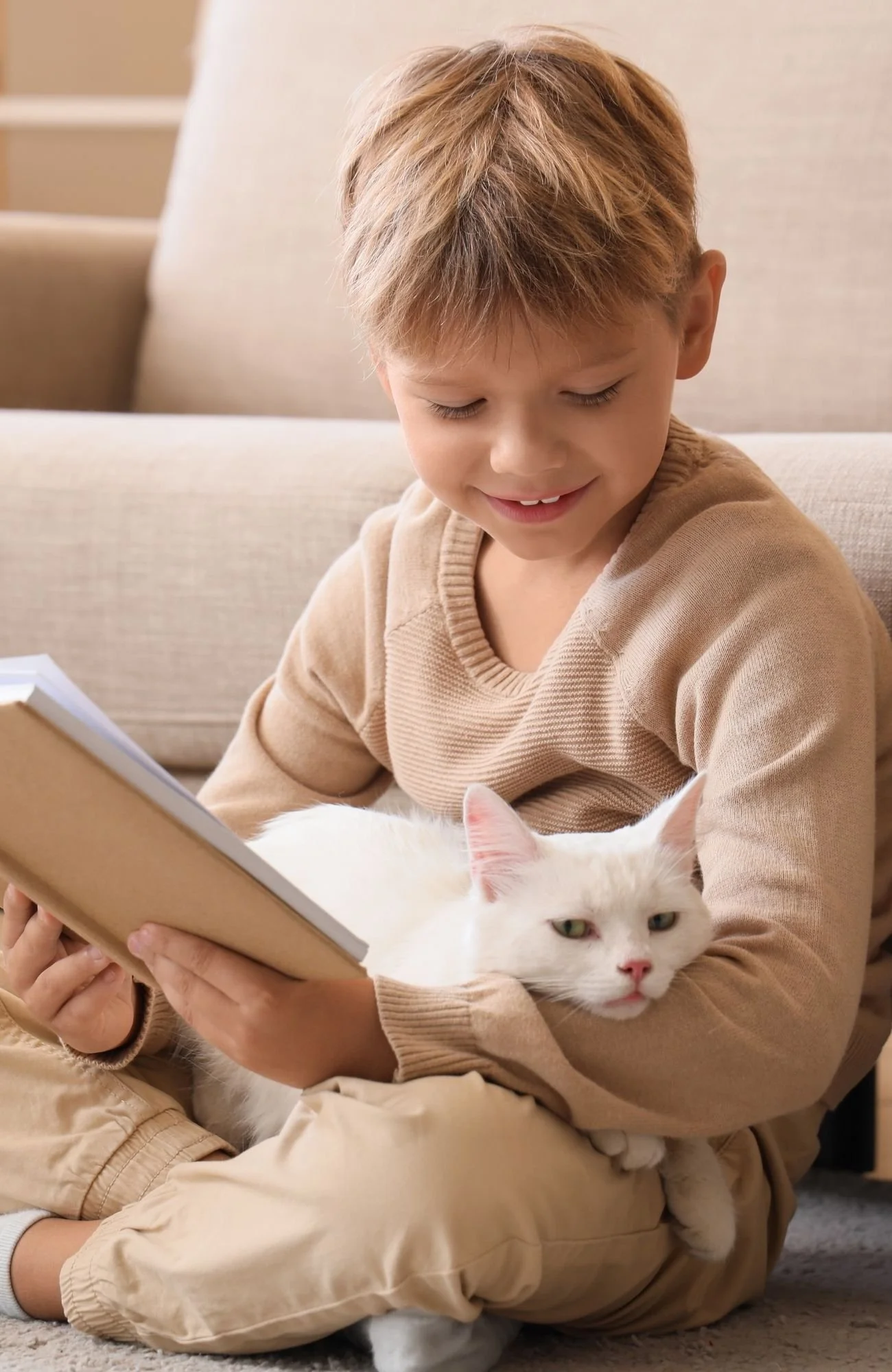 A kid holding his cat reading a book about companion animal loss after in-home pet euthanasia in Vancouver