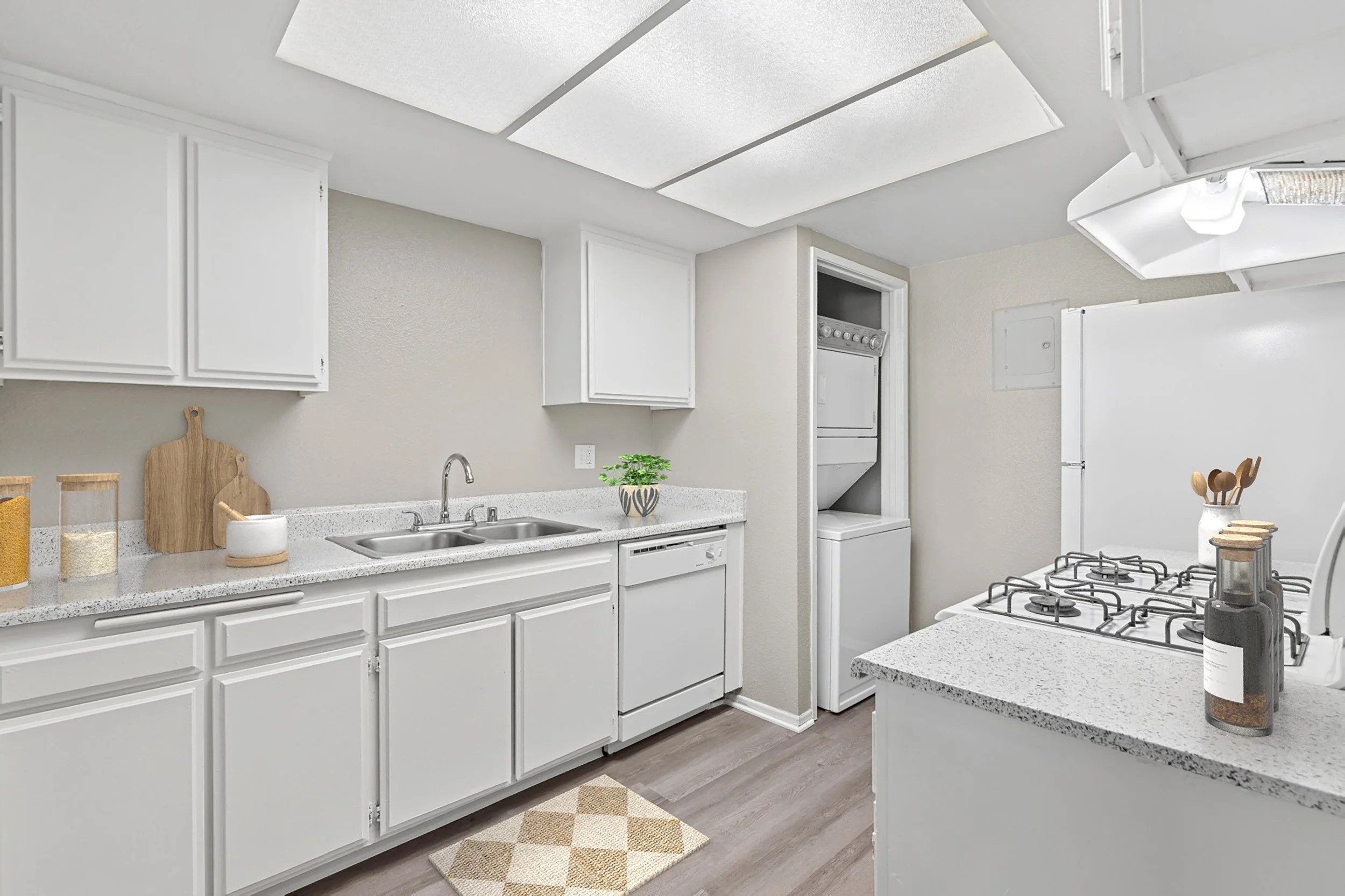 An all-white kitchen, staged with beautiful accessories for your cooking needs. 