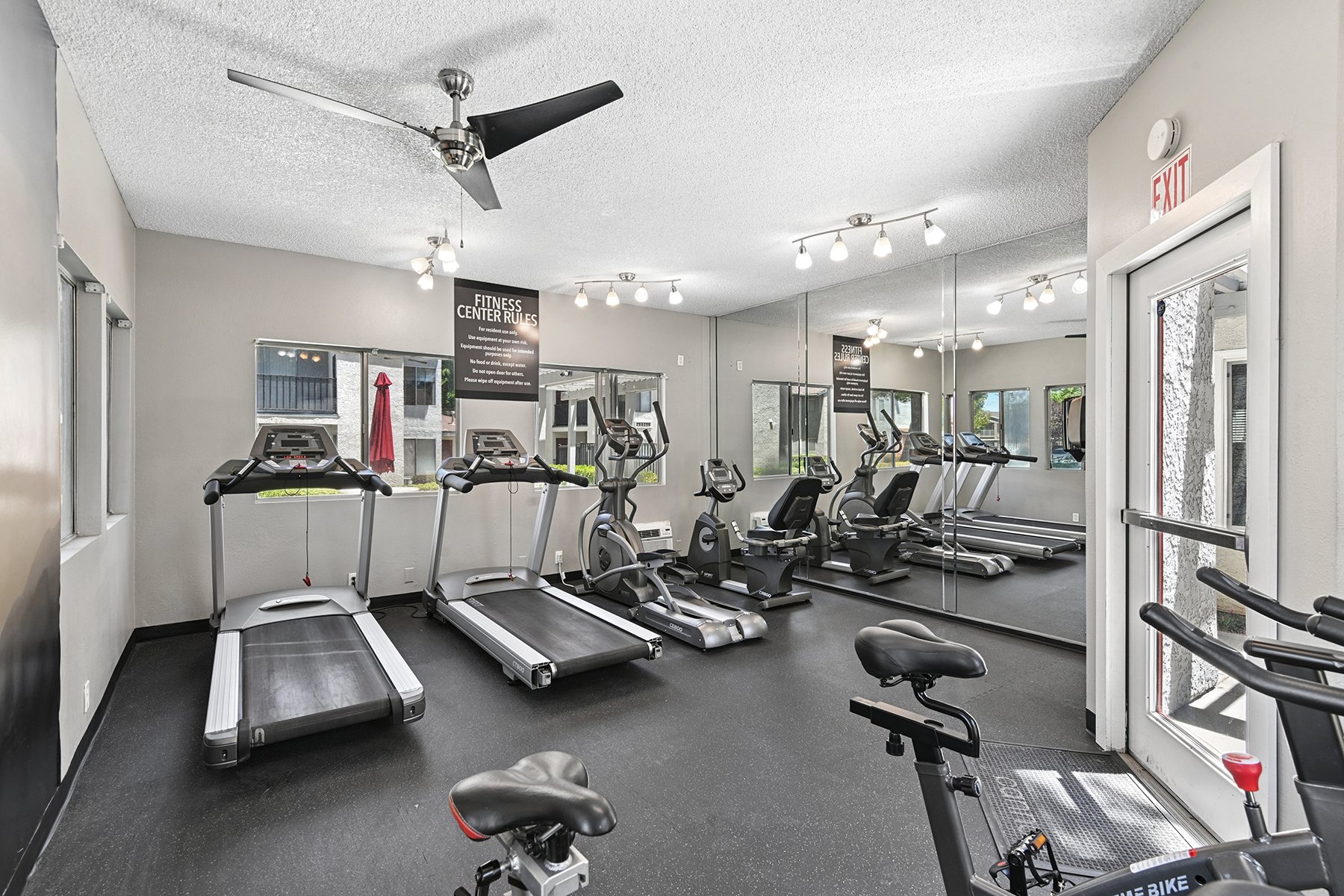 Fitness Center at Town Square Apartments with plenty of equipment, natural lighting, and large windows. 
