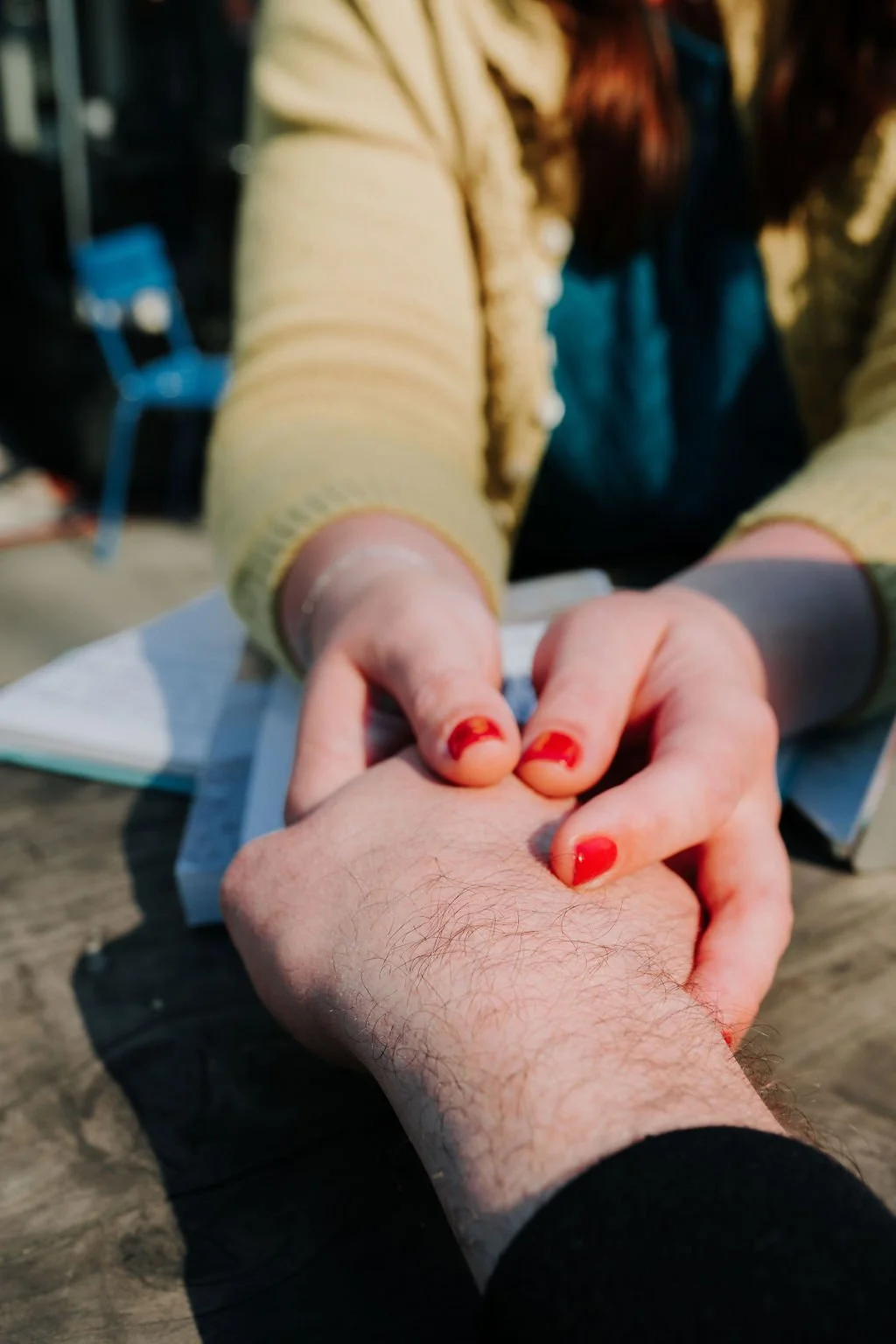 person with red nails holding another person's hand